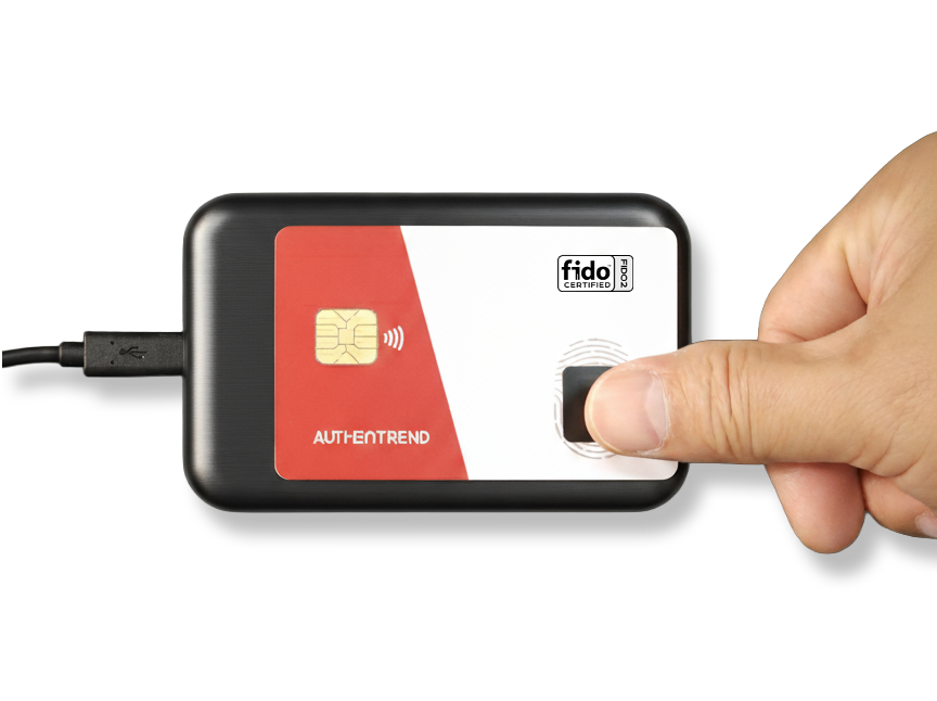 A person using their thumb to scan a fingerprint on a black electronic device connected with a cable, with a red and white label and various icons.