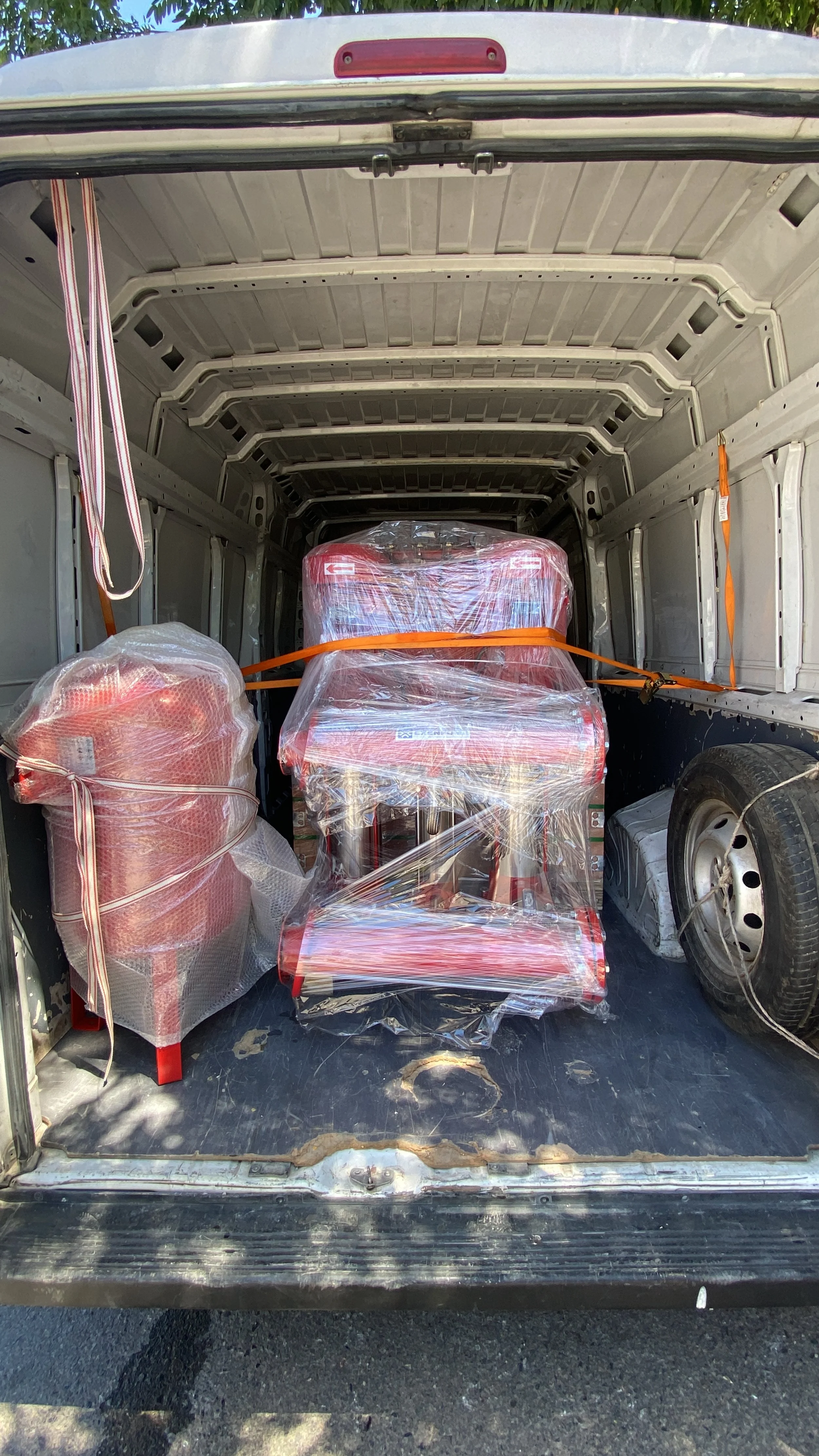Fire extinguishers and equipment secured with straps inside a cargo van.