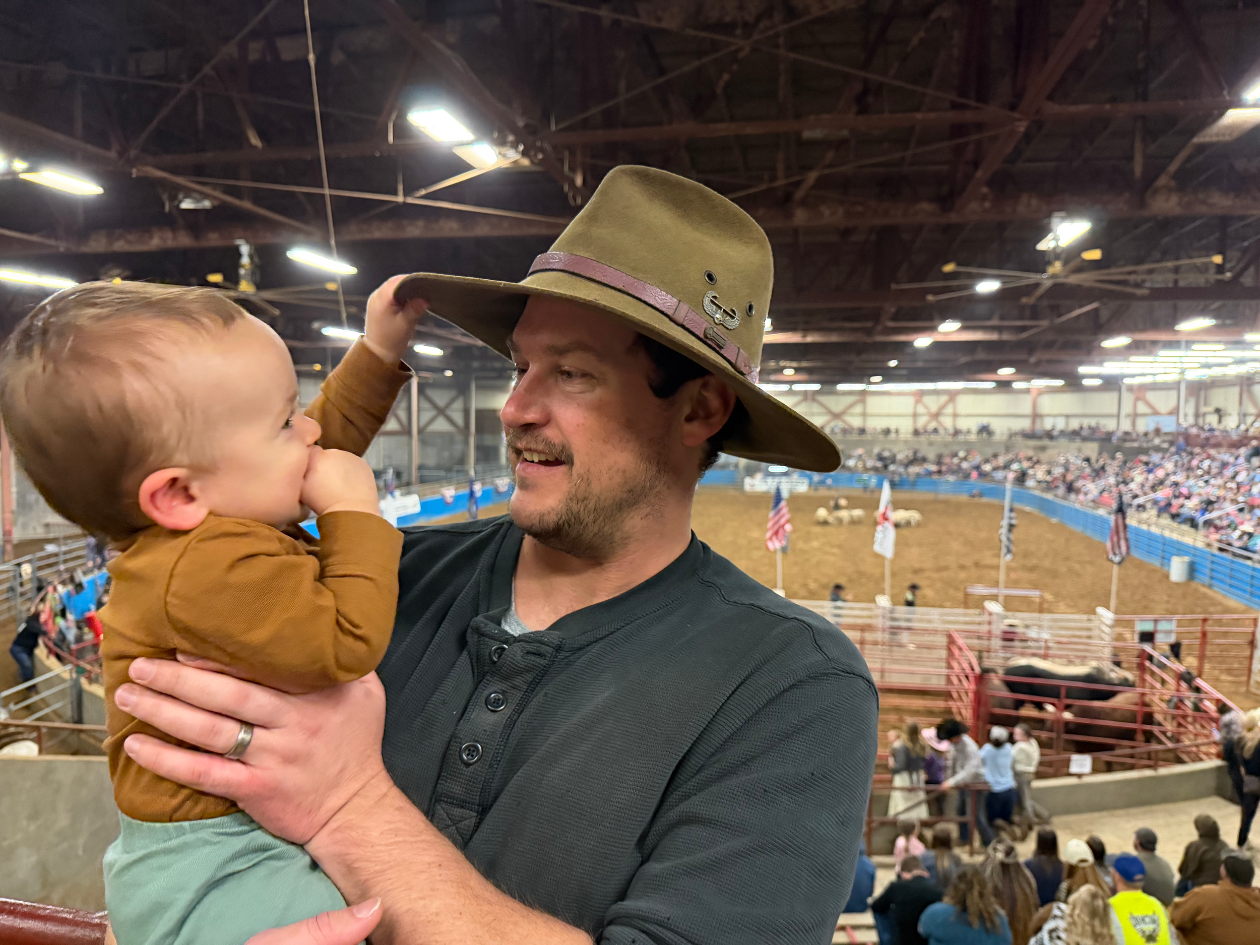 Father holding his one-year-old son while sharing a smile at a Virginia rodeo.