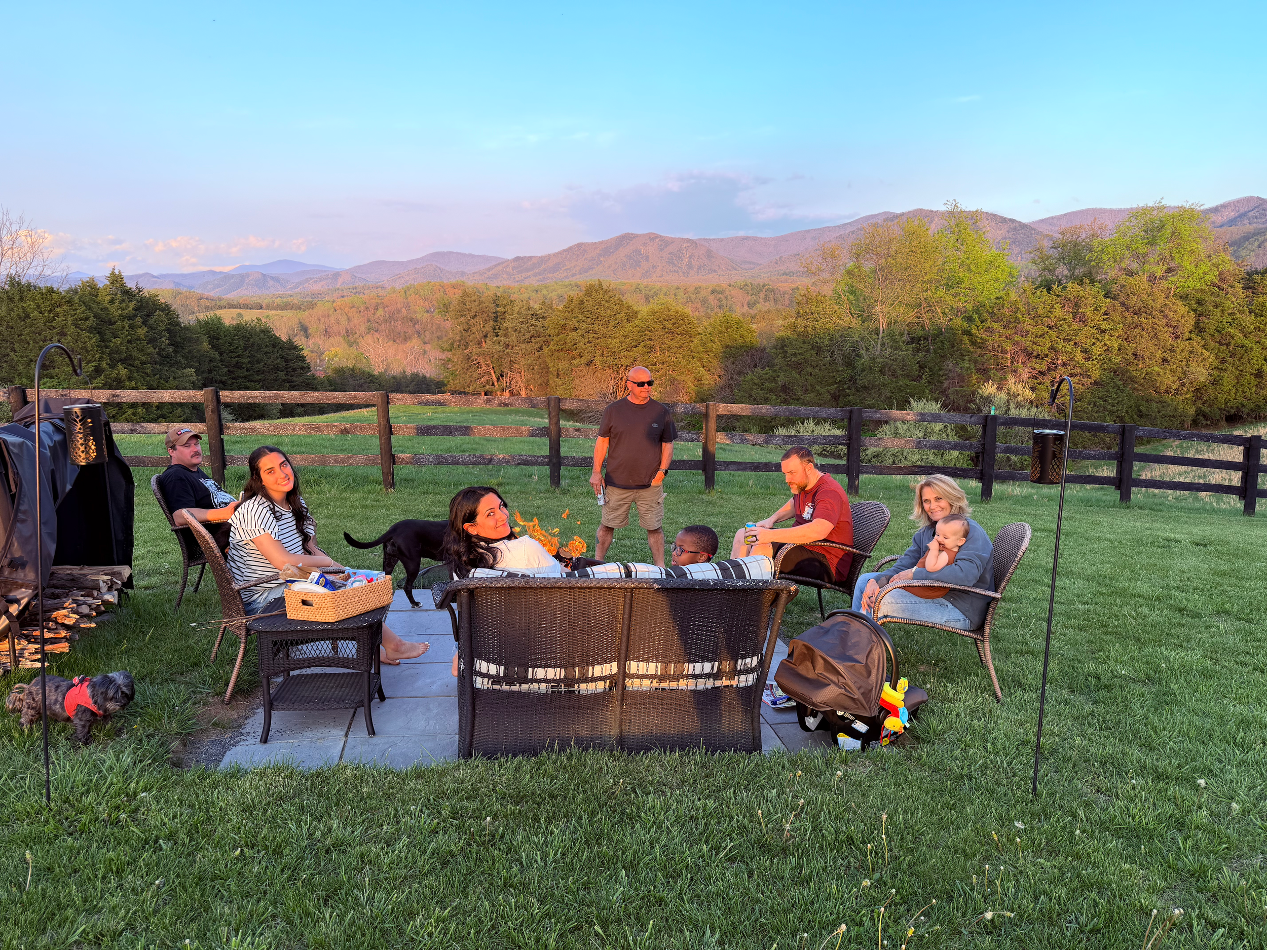 Family gathered around a fire pit overlooking the Blue Ridge Mountains during a birthday vacation.