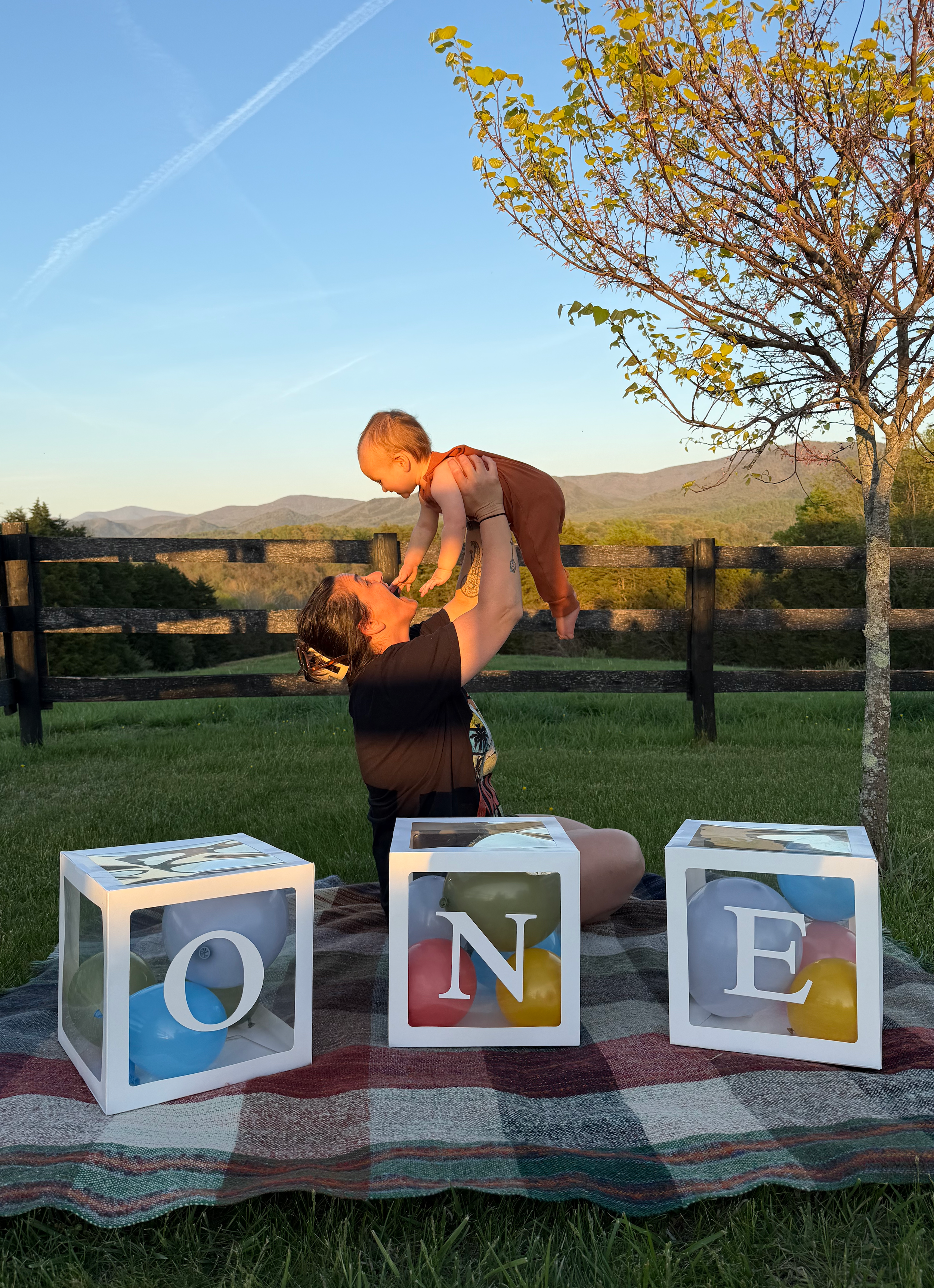 Mother lifting her one-year-old son during a mountain birthday celebration in Virginia while living full-time in an RV.