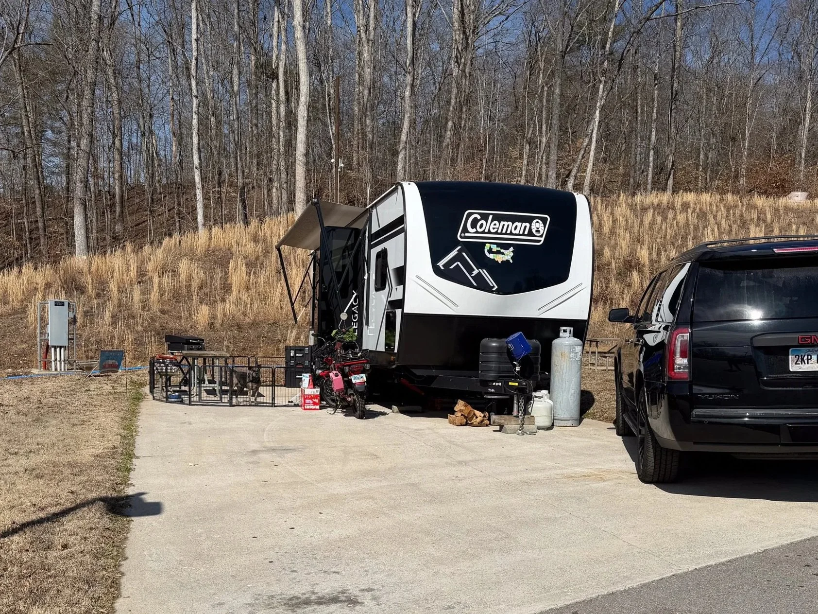 Full-time RV setup at a quiet campground with travel trailer and family vehicle parked, representing intentional road life with a baby.