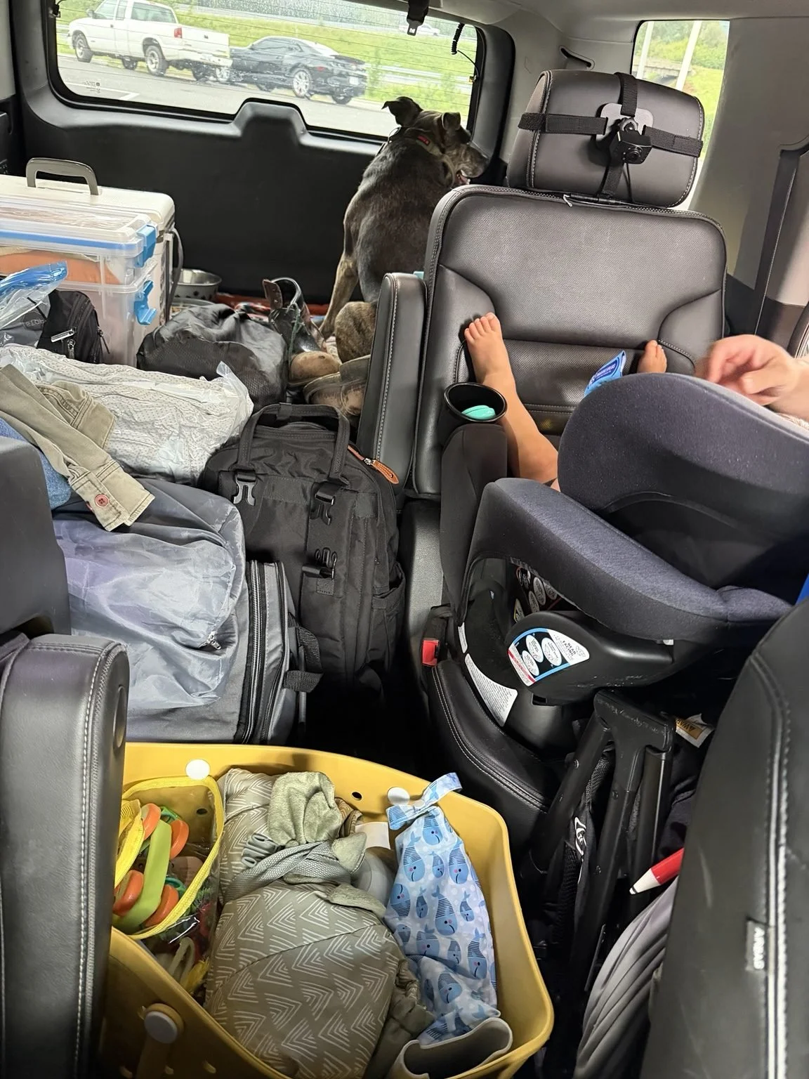 Travel bag packed between the seats of a Yukon with toddler gear ready for a road trip.