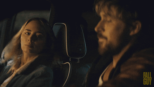 A man and woman sitting in a car at night, having a conversation.