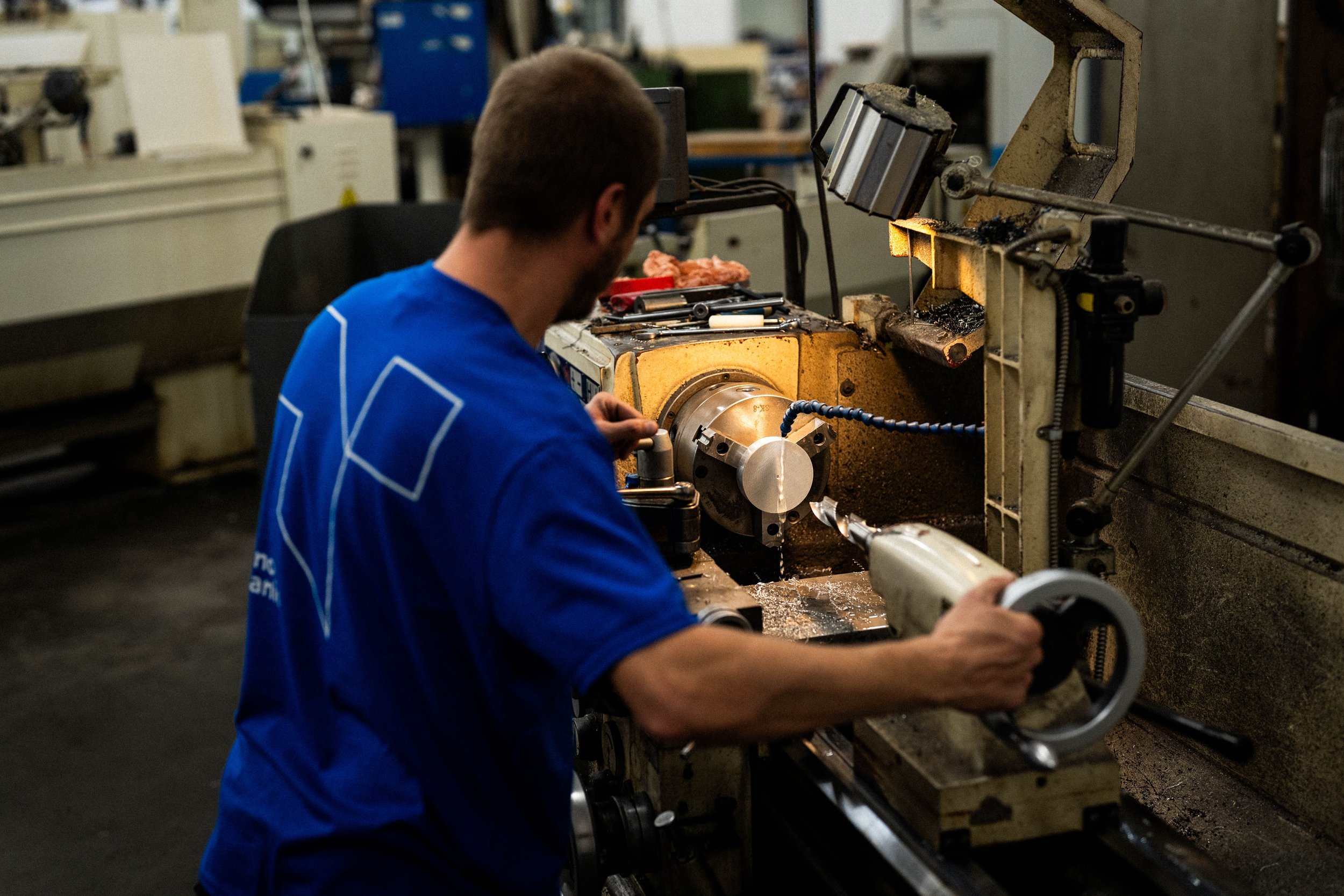 Un homme travaille avec une machine-outil dans un atelier de fabrication.