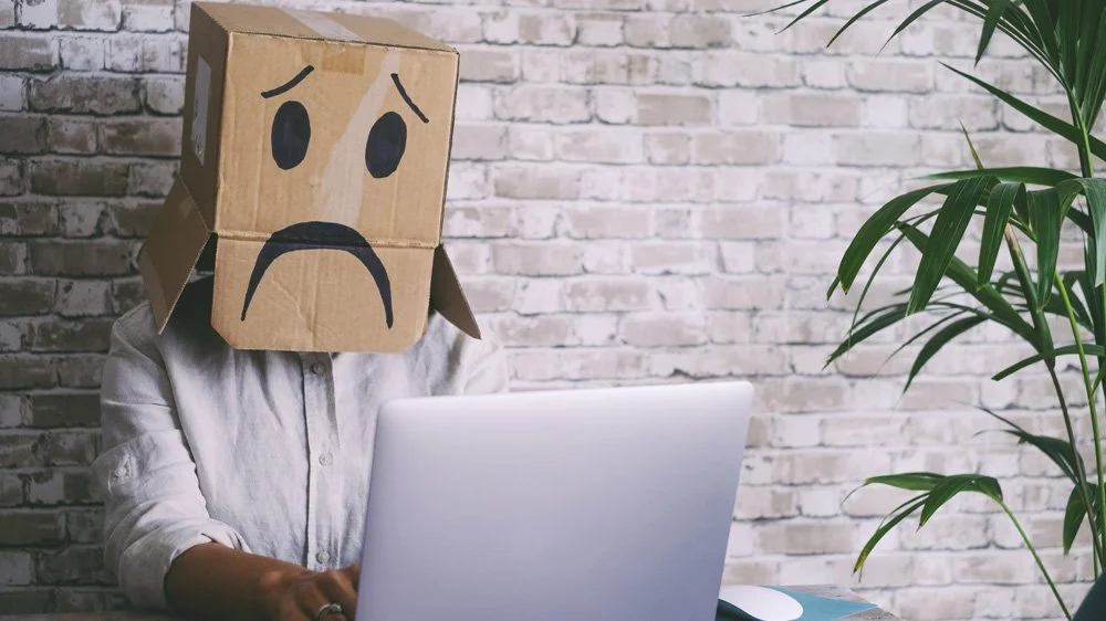 Unhappy person behind a laptop