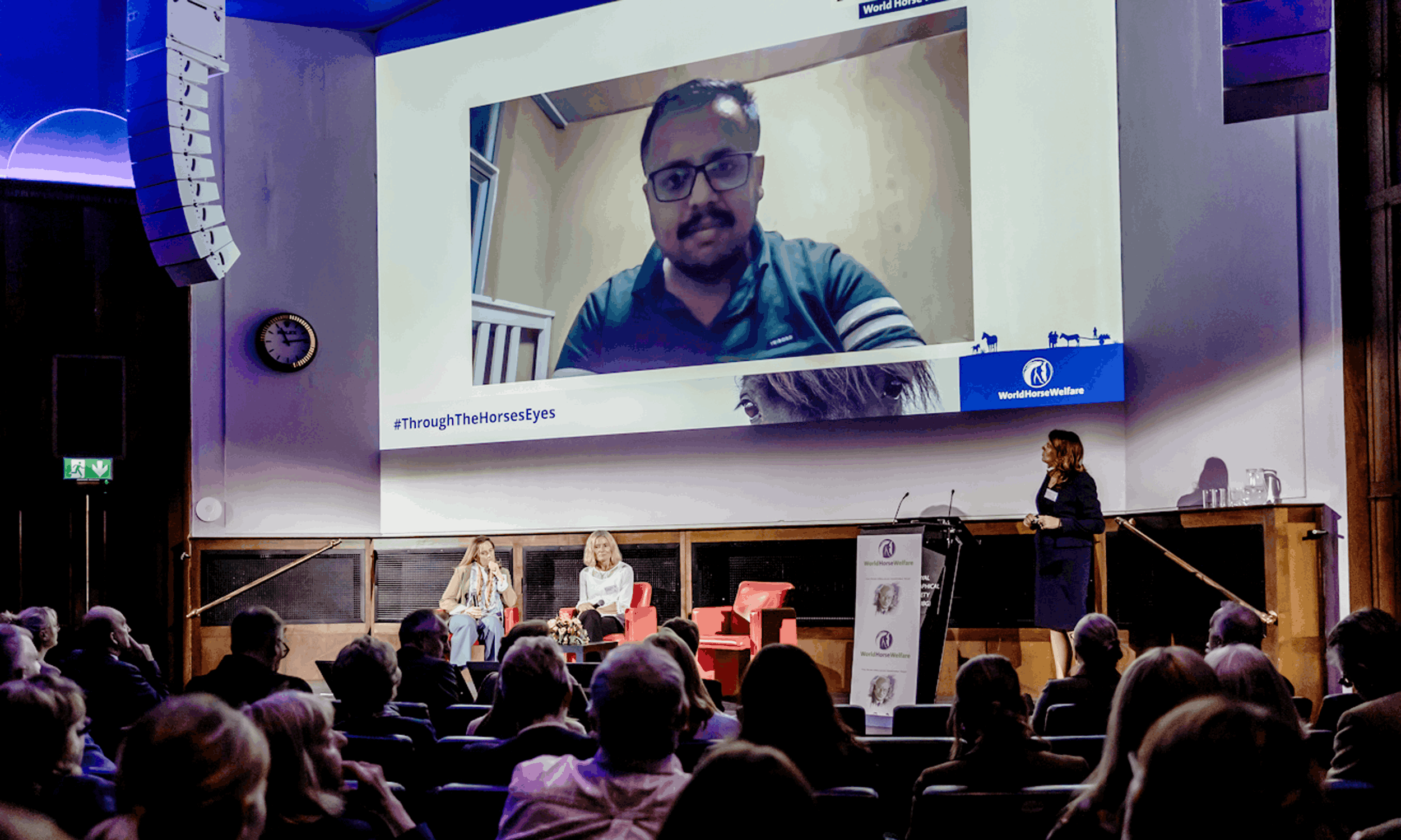 Hybrid event production with a remote speaker appearing live on screen for an in-room audience