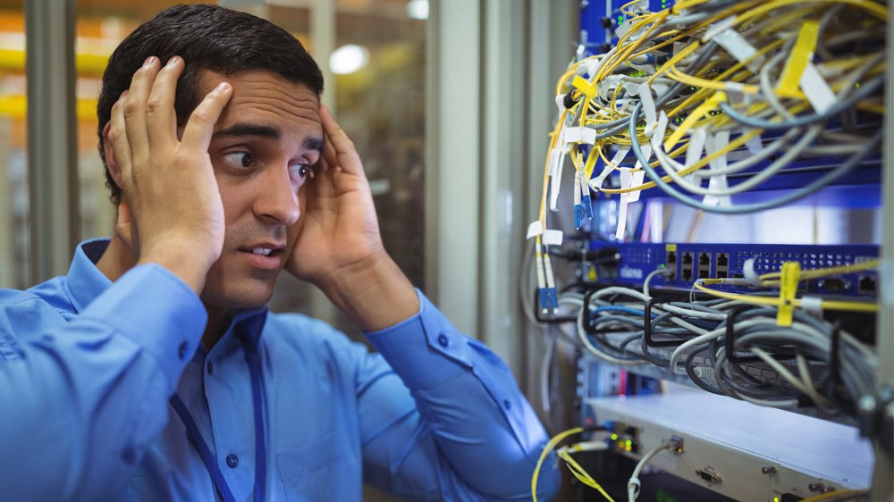 Stressed man looking at computer cables
