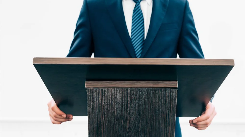 Business presenter stood at a lectern
