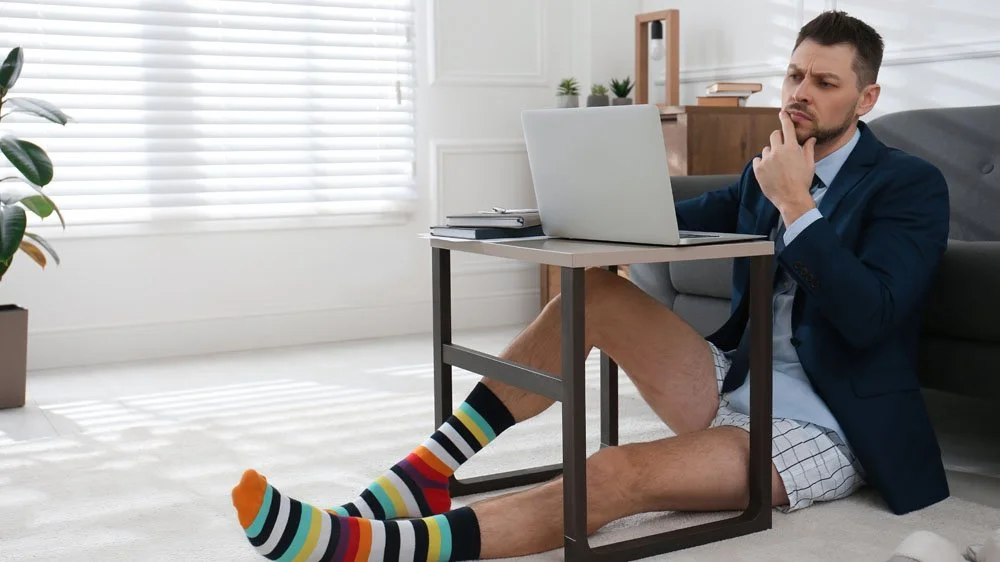 Casual online conference speaker sat at home on their laptop