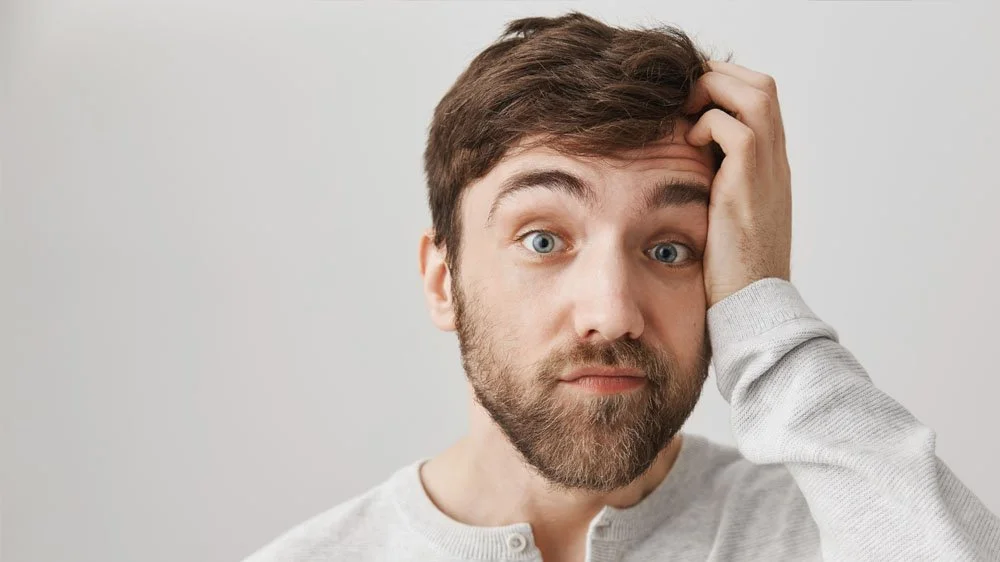 Man looking into the camera confused