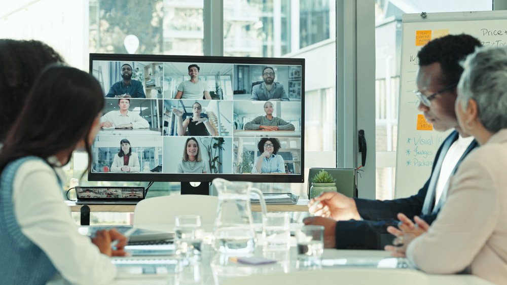 People sat around a big screen watching a webinar