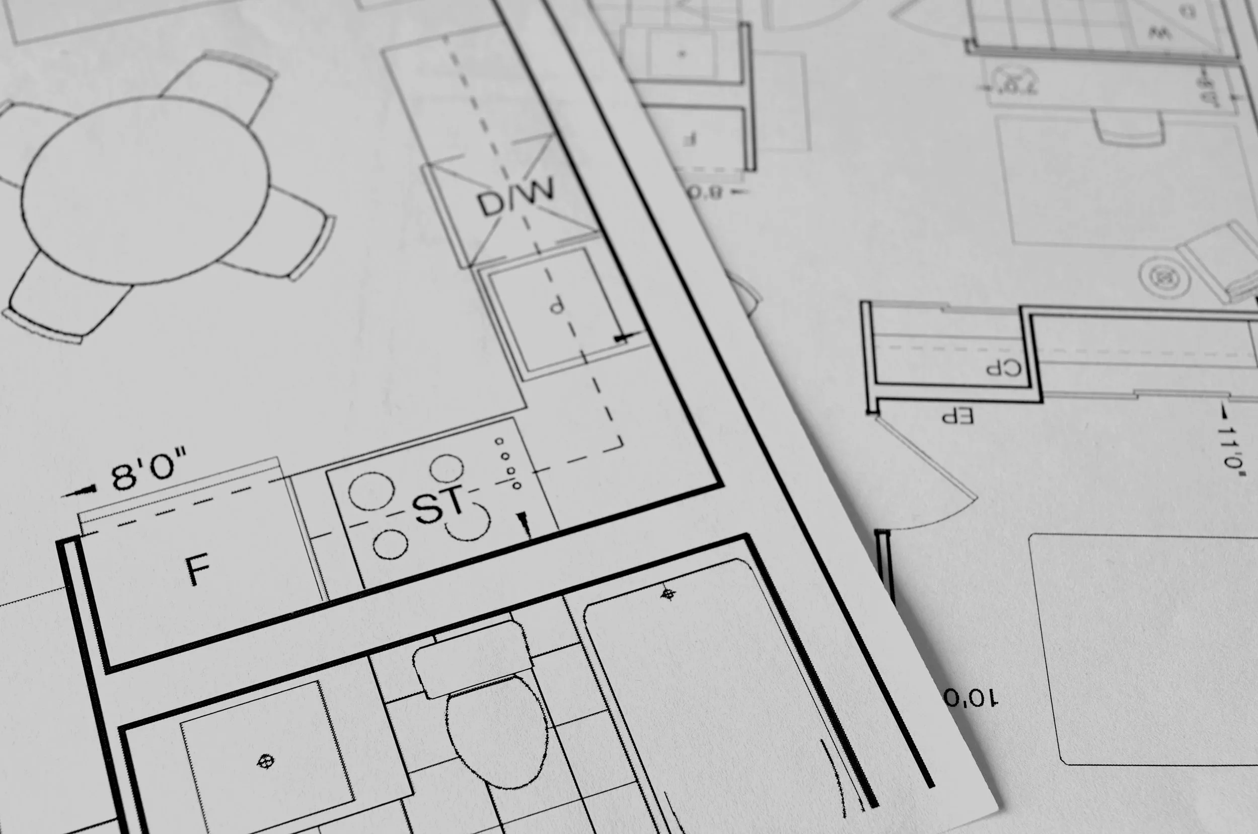 Architectural blueprint showing various rooms, walls, and structural details of a building layout, including a kitchen area with appliances and a dining space.