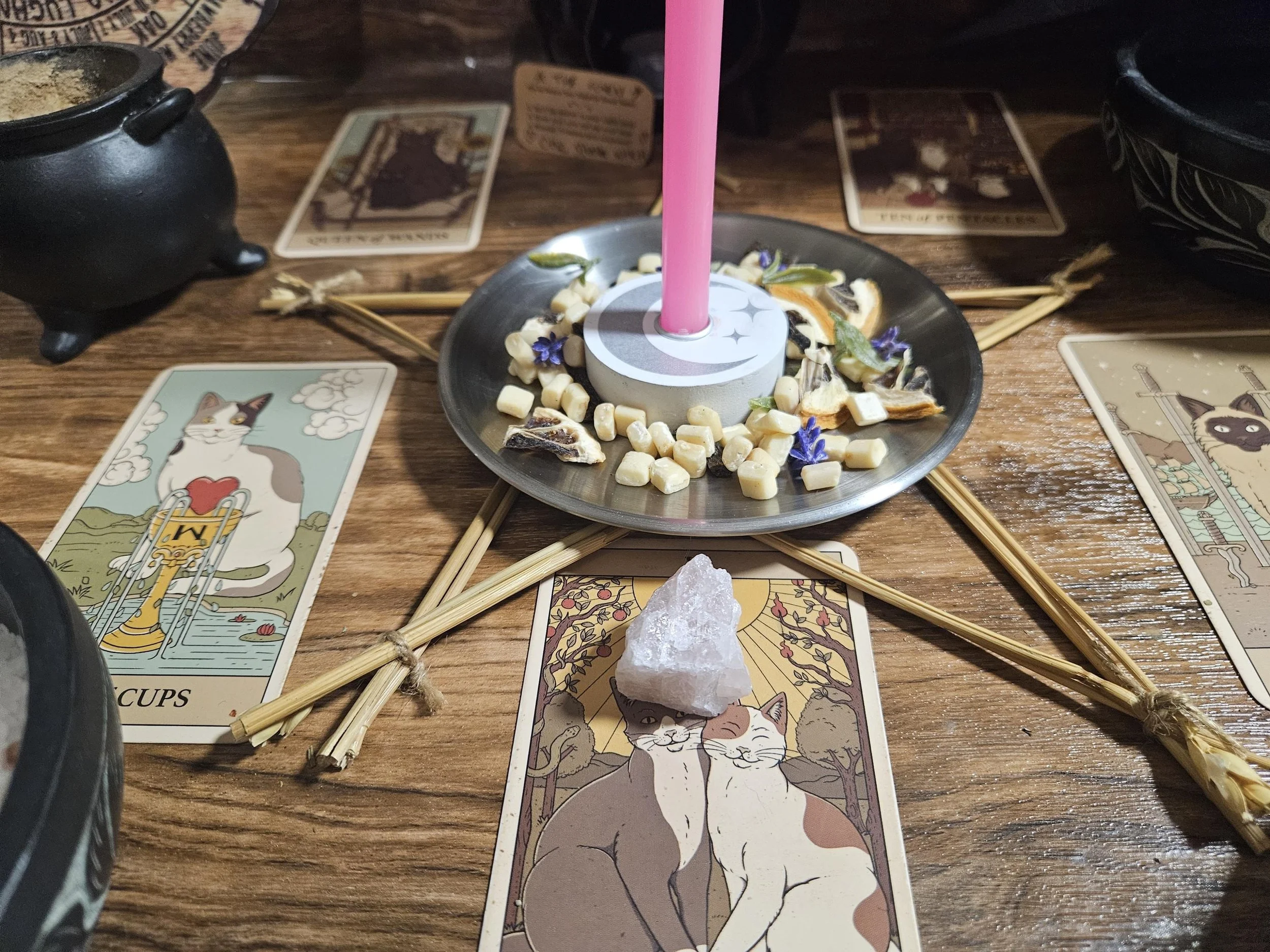 Rose Quartz gemstone pendant talisman on an altar with pink candles and dried petals.