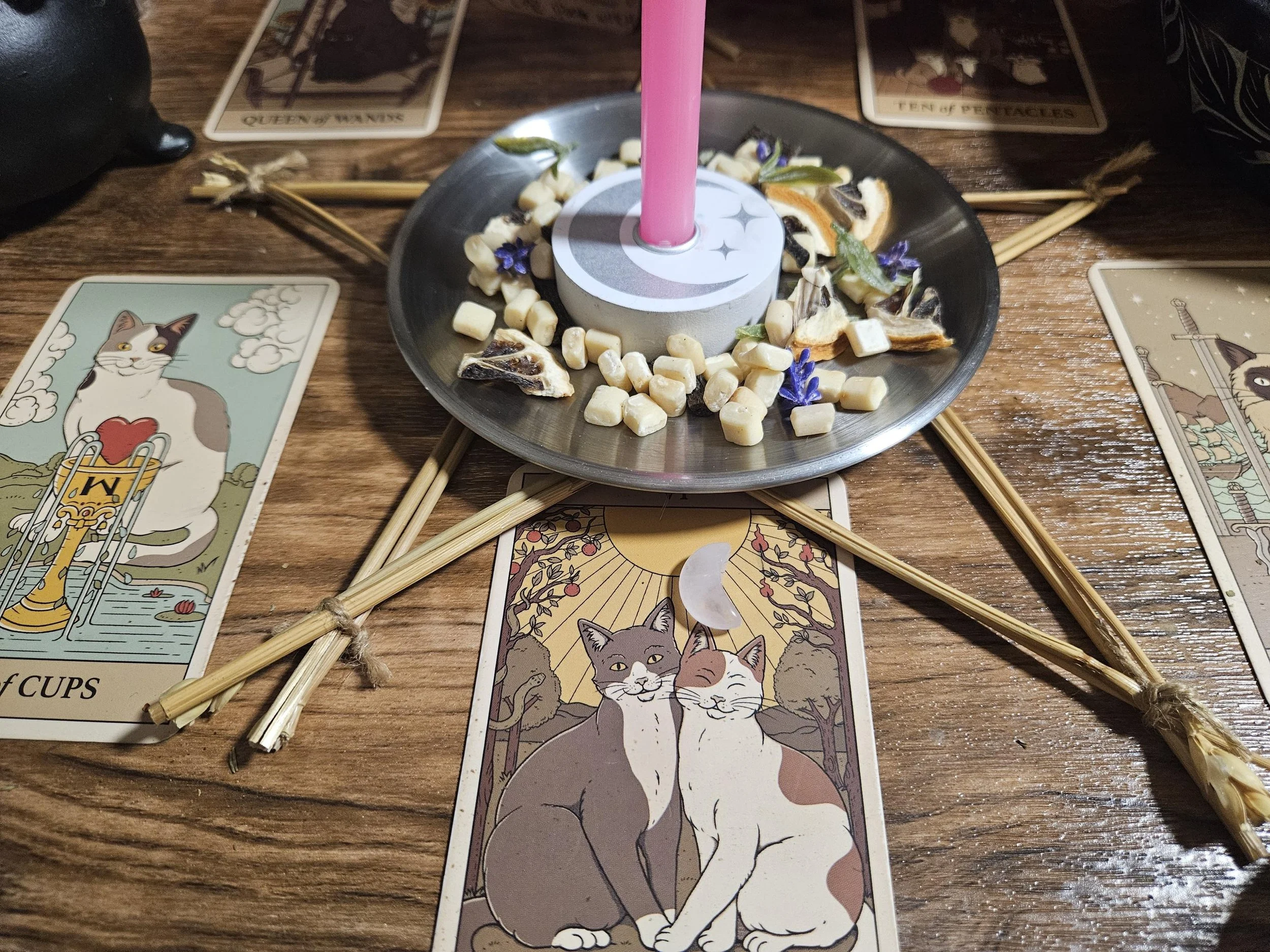 Rose Quartz gemstone pendant talisman on an altar with pink candles and dried petals.