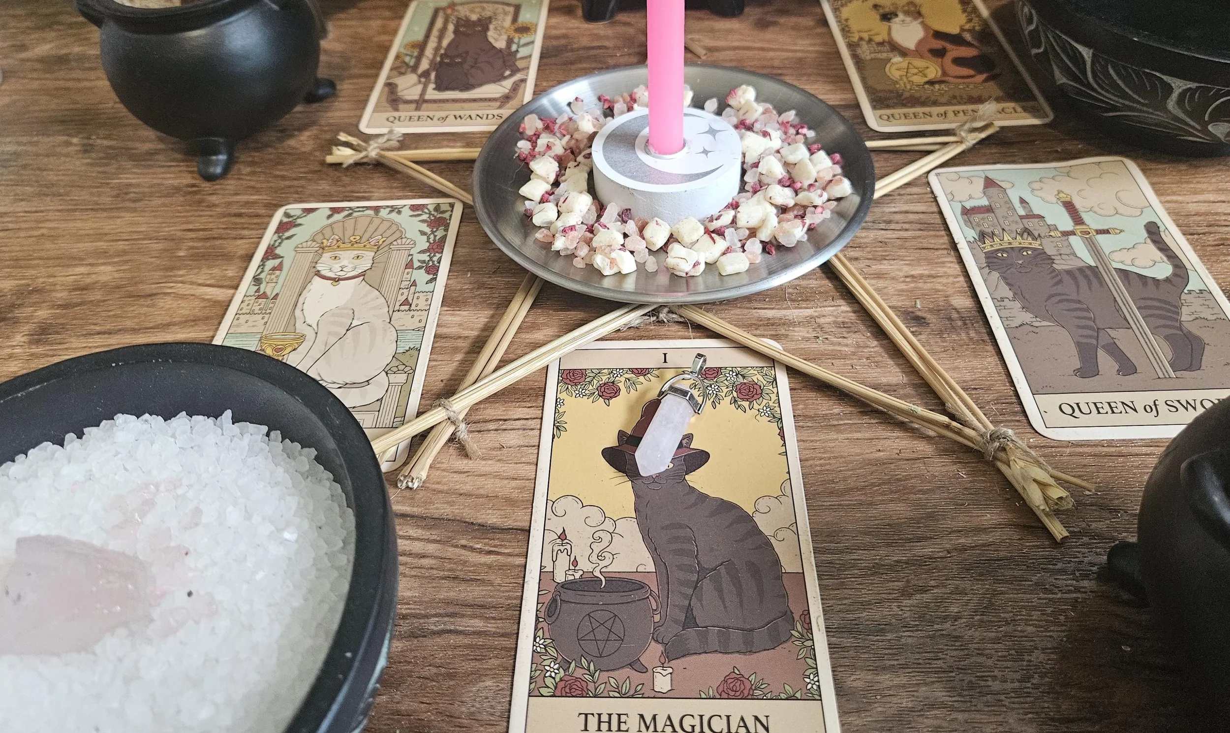 Rose Quartz gemstone pendant talisman on an altar with pink candles and dried petals.