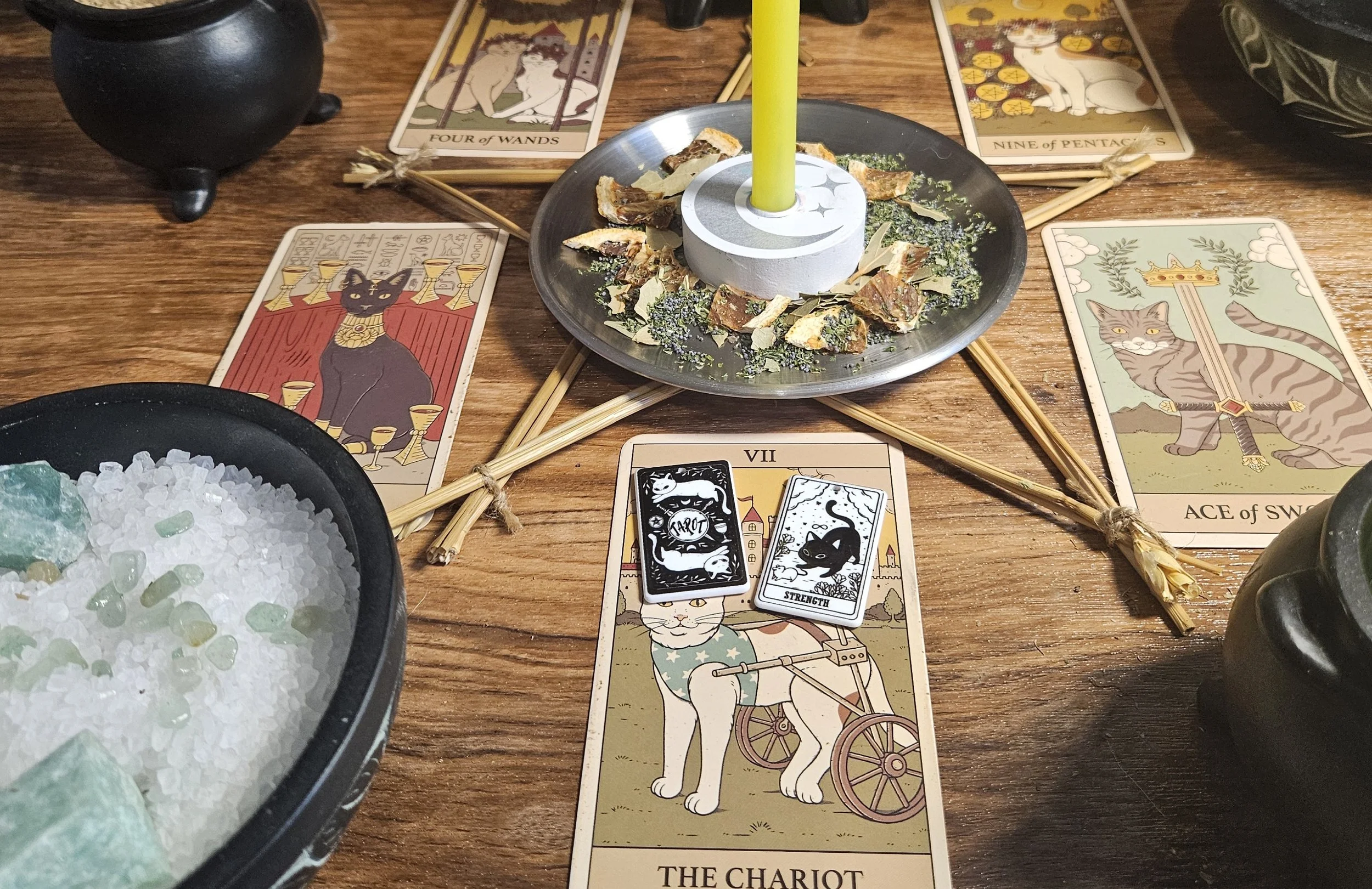 A table displaying tarot cards, lit candles, and various mystical items for a divination session