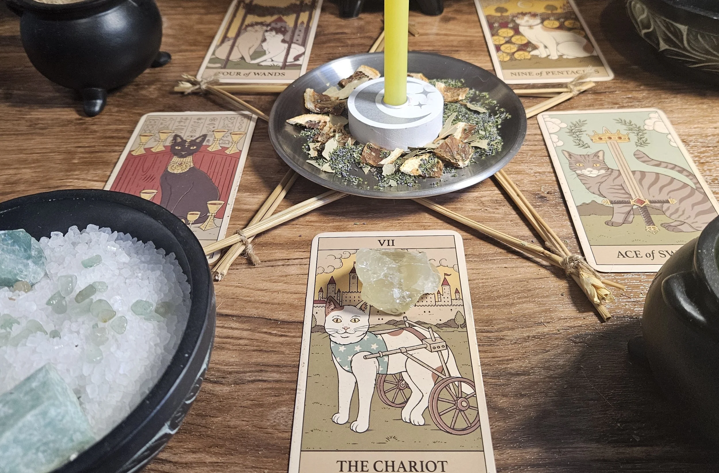 A table displaying tarot cards, lit candles, and various mystical items arranged for a reading session.