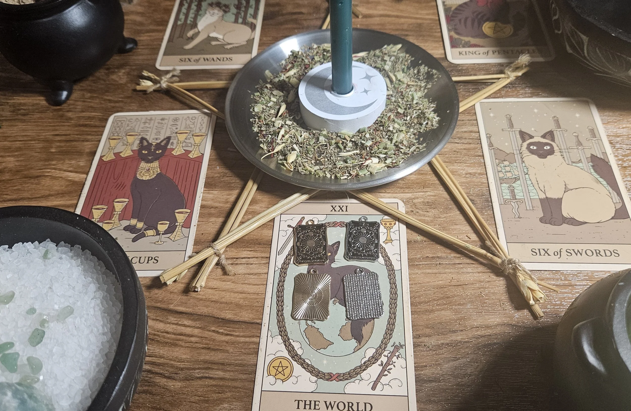 A tarot card deck featuring a candle resting on it, symbolizing illumination and insight during readings.