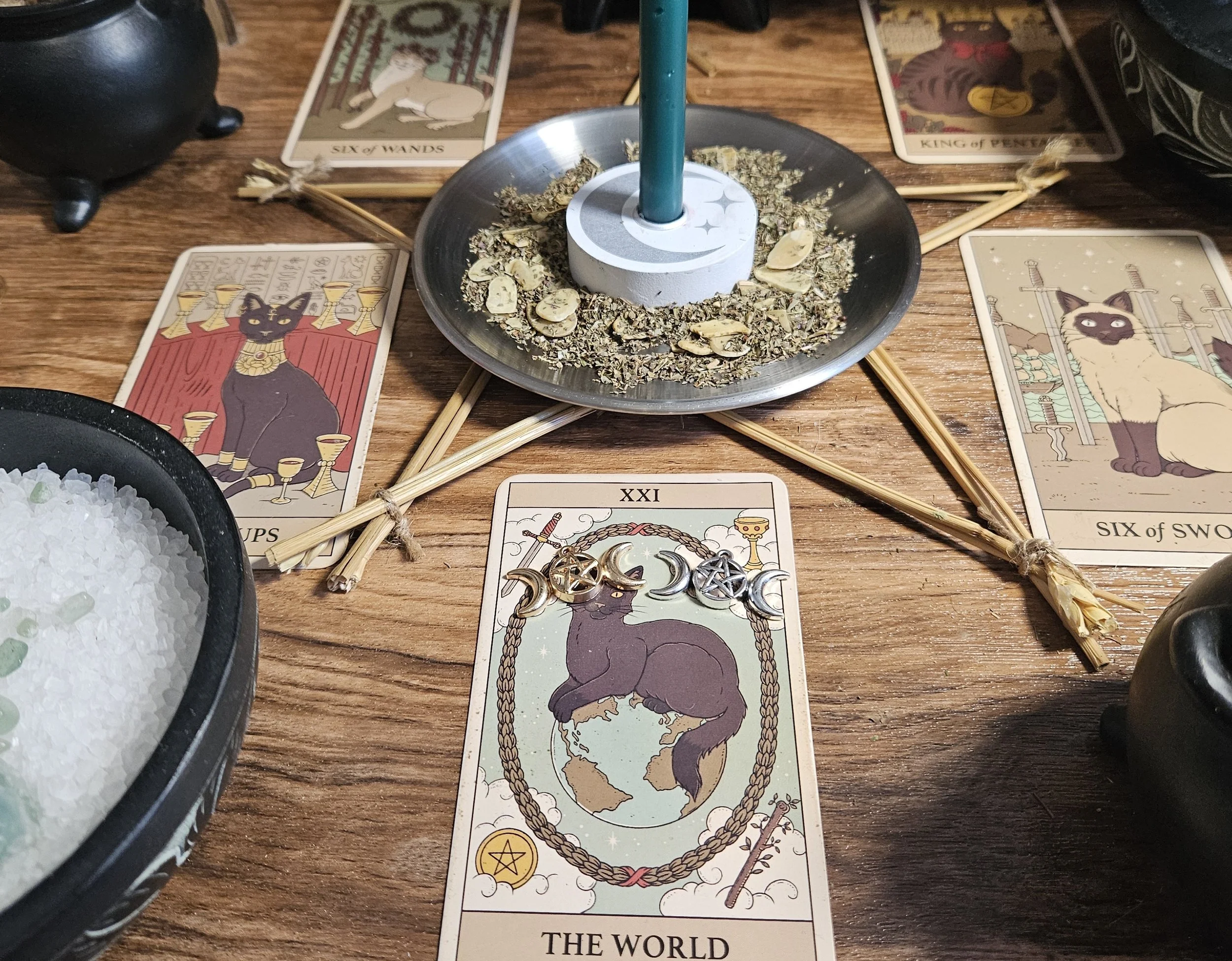 A table displaying tarot cards arranged in a spread, accompanied by a lit candle for ambiance.