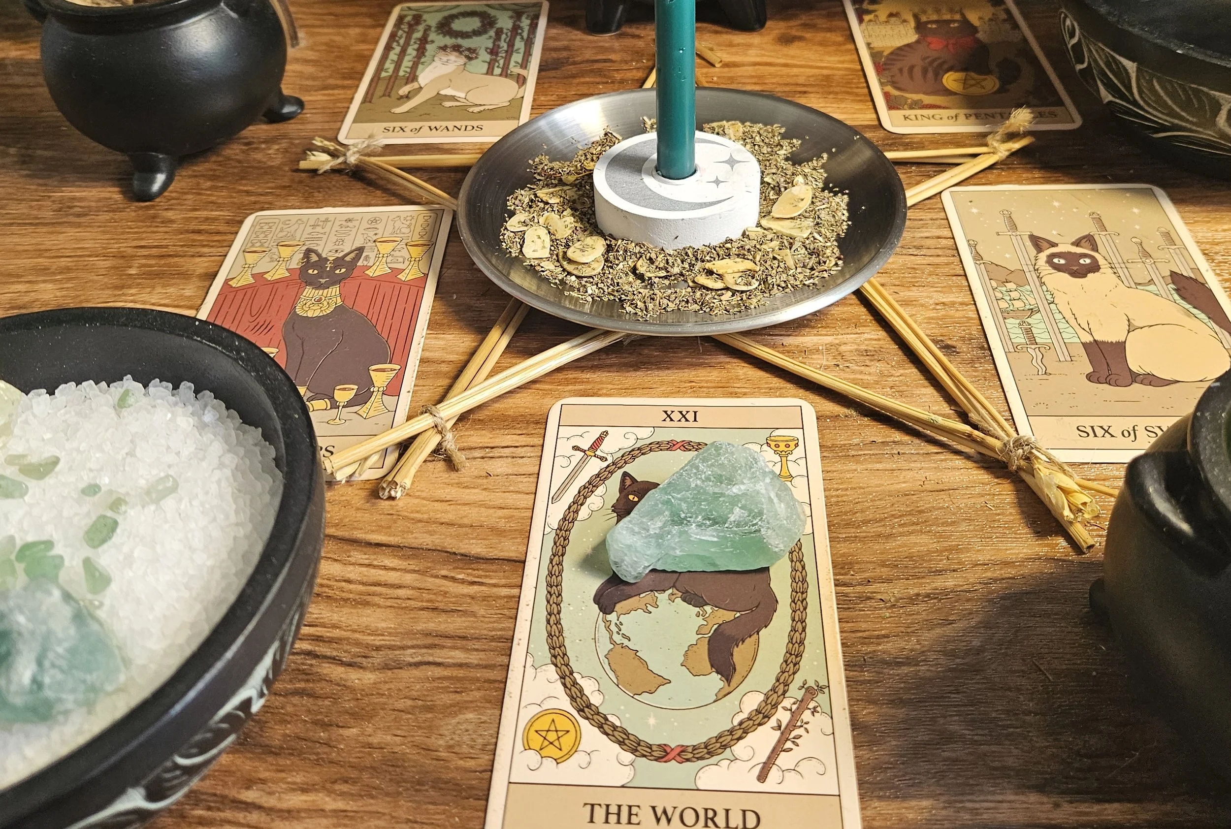 A tabletop set with tarot cards laid out and a glowing candle, suggesting a tarot reading session.