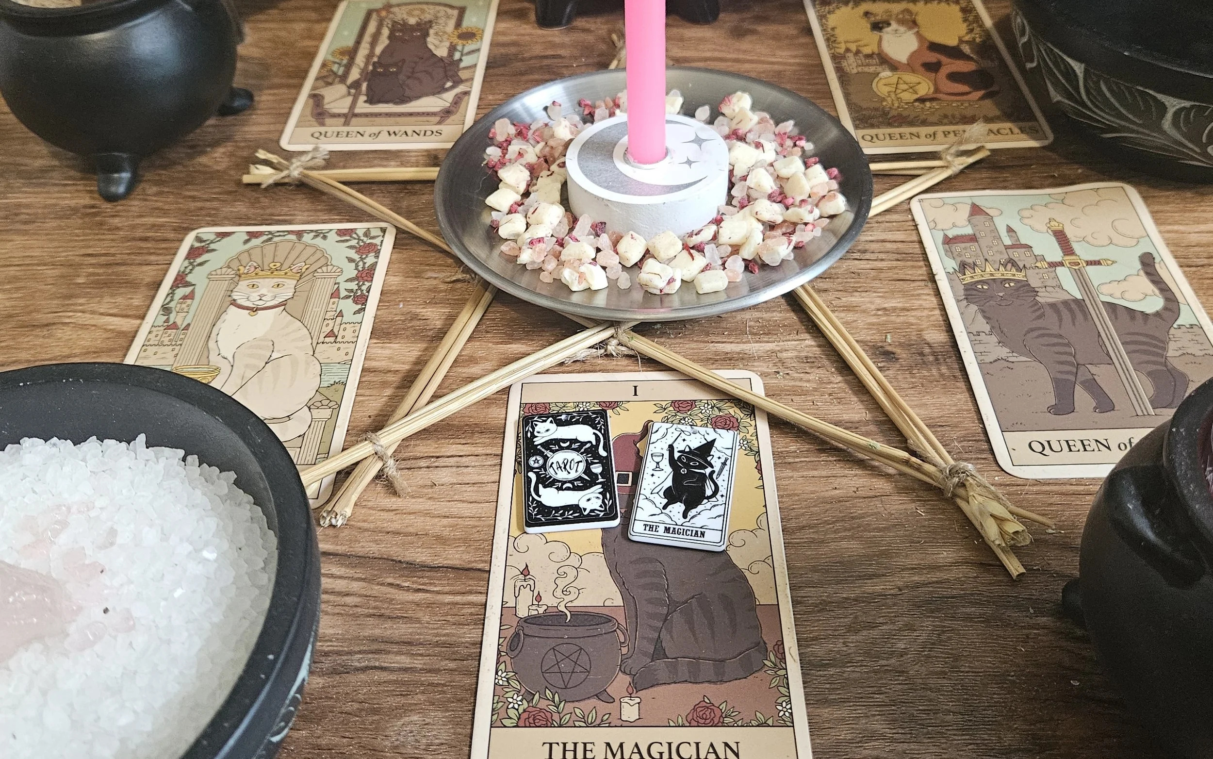 A tarot card layout on a table, accompanied by several candles, suggesting a serene and spiritual reading environment.