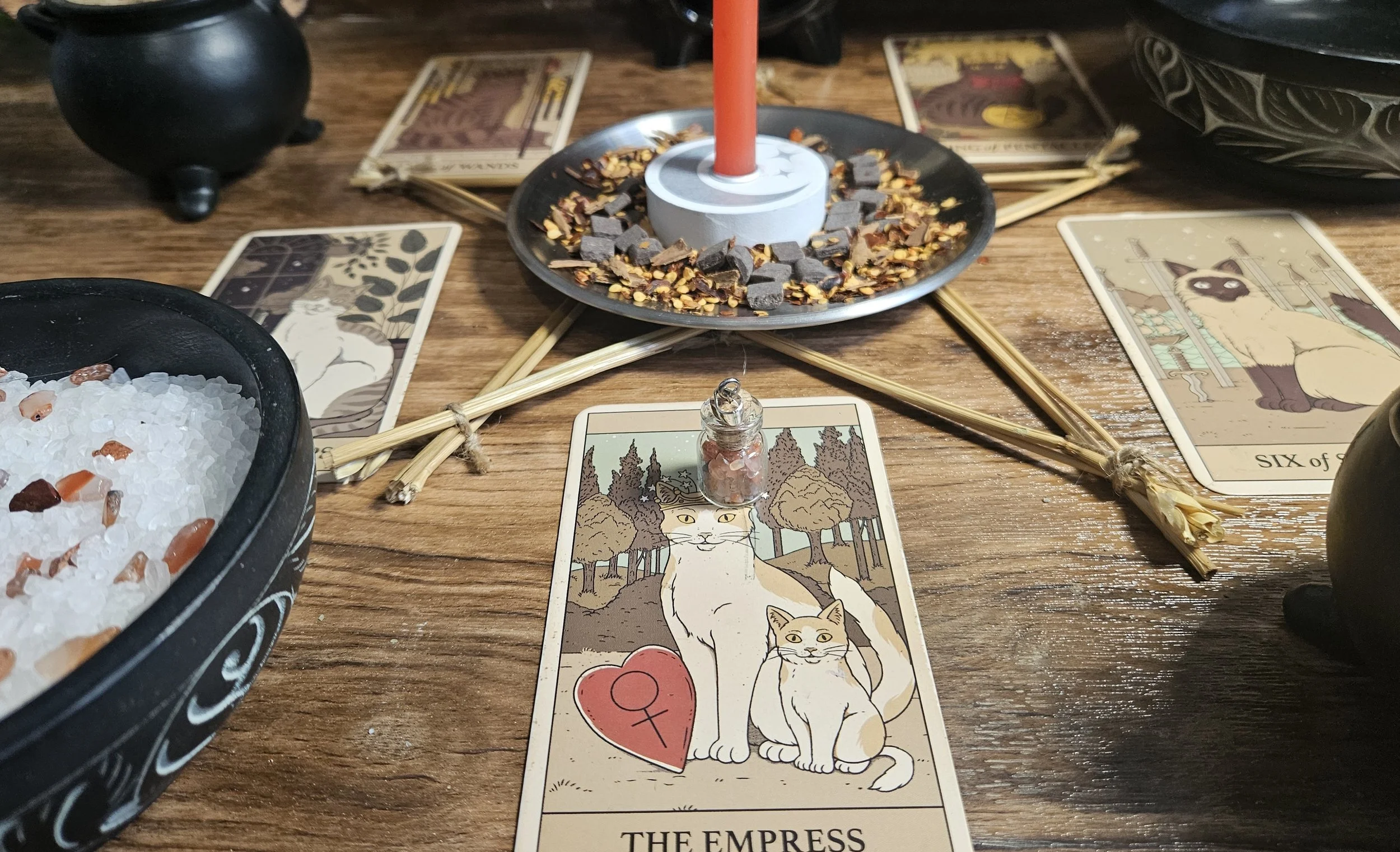 A tarot card featuring a cat sitting beside a lit candle, symbolizing intuition and mystery.