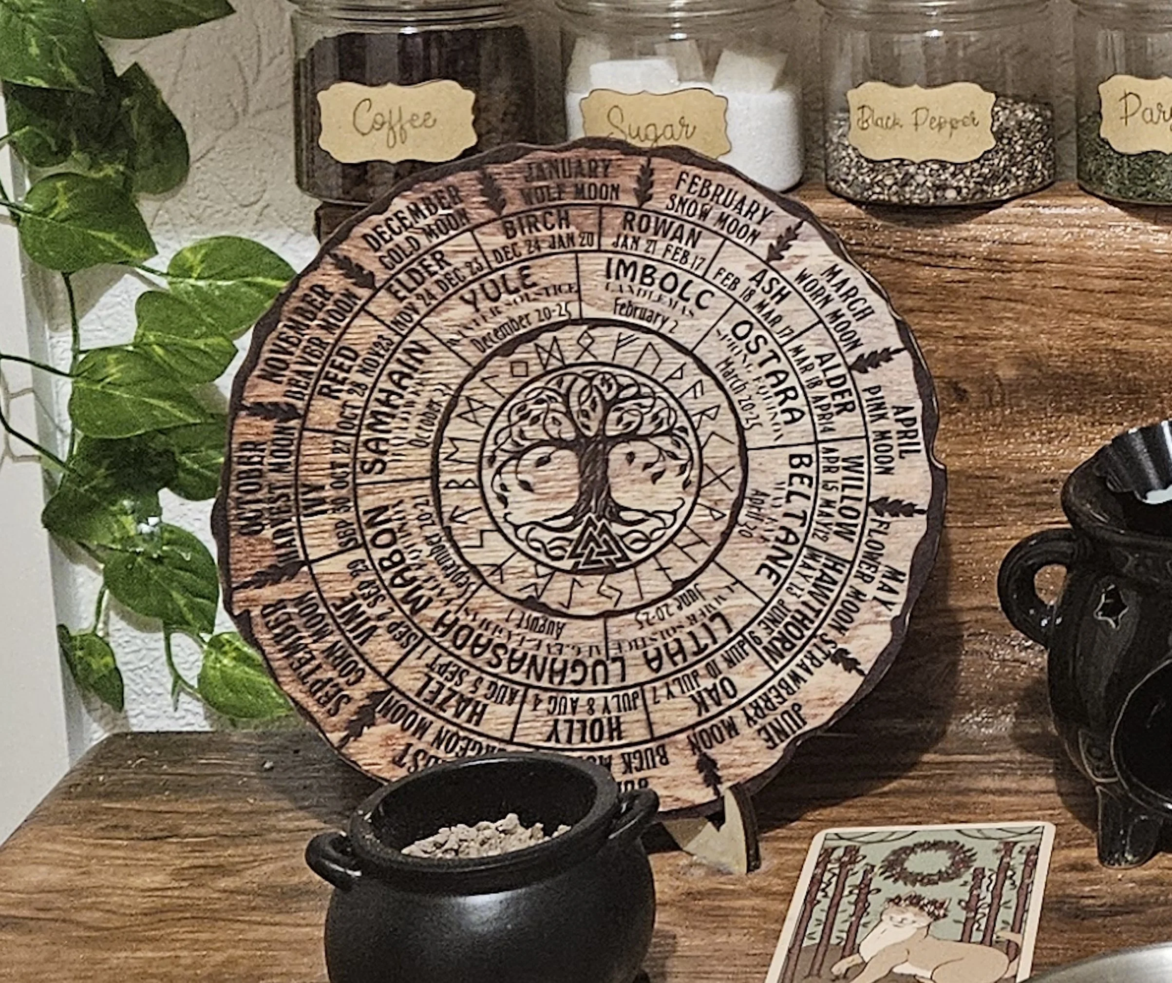 A beautiful rustic flatlay of a circular wooden wheel symbol surrounded by seasonal items like pinecones, dried flowers, small crystals, and autumn leaves.
