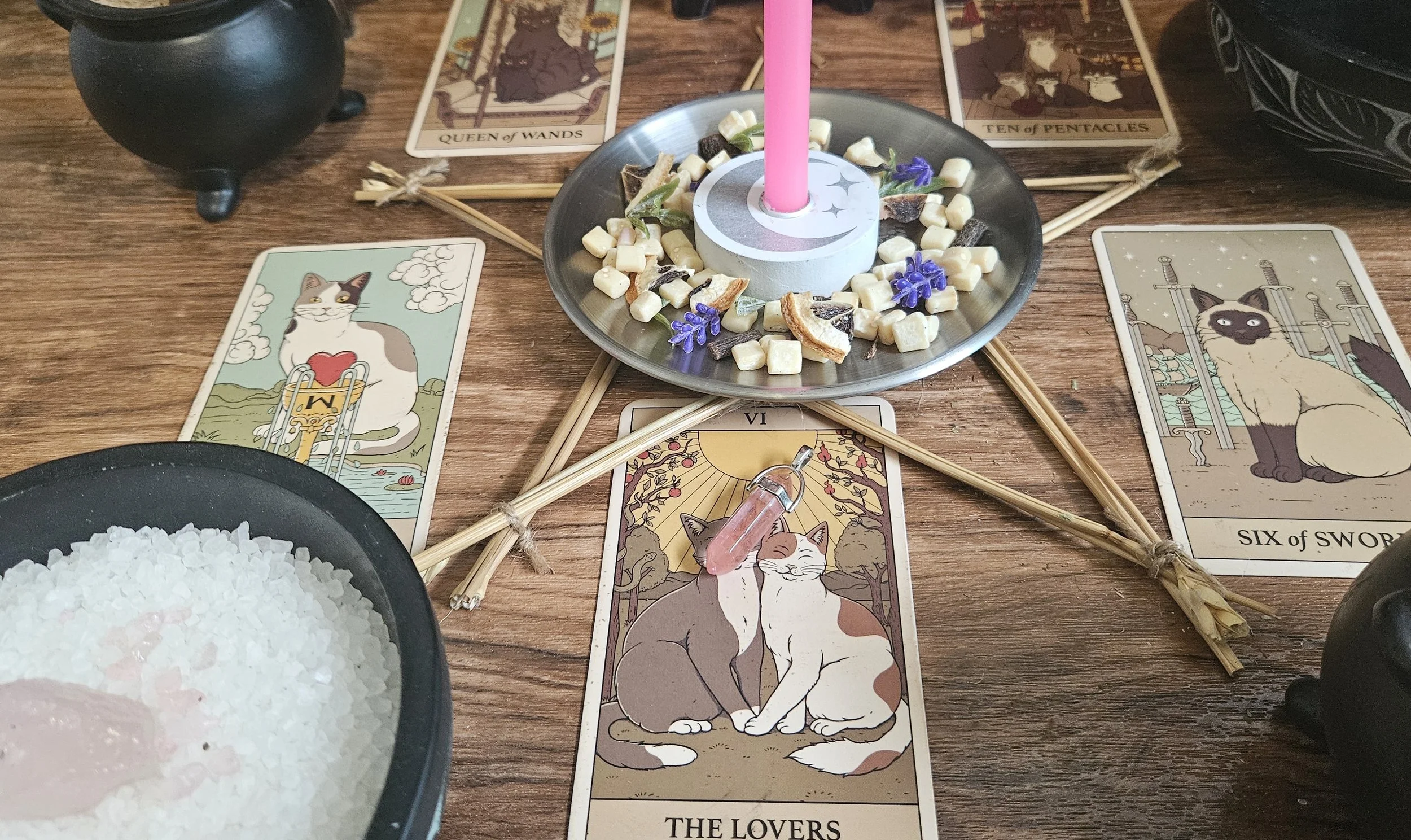 A table displaying tarot cards arranged in a spread, accompanied by a lit candle for ambiance.