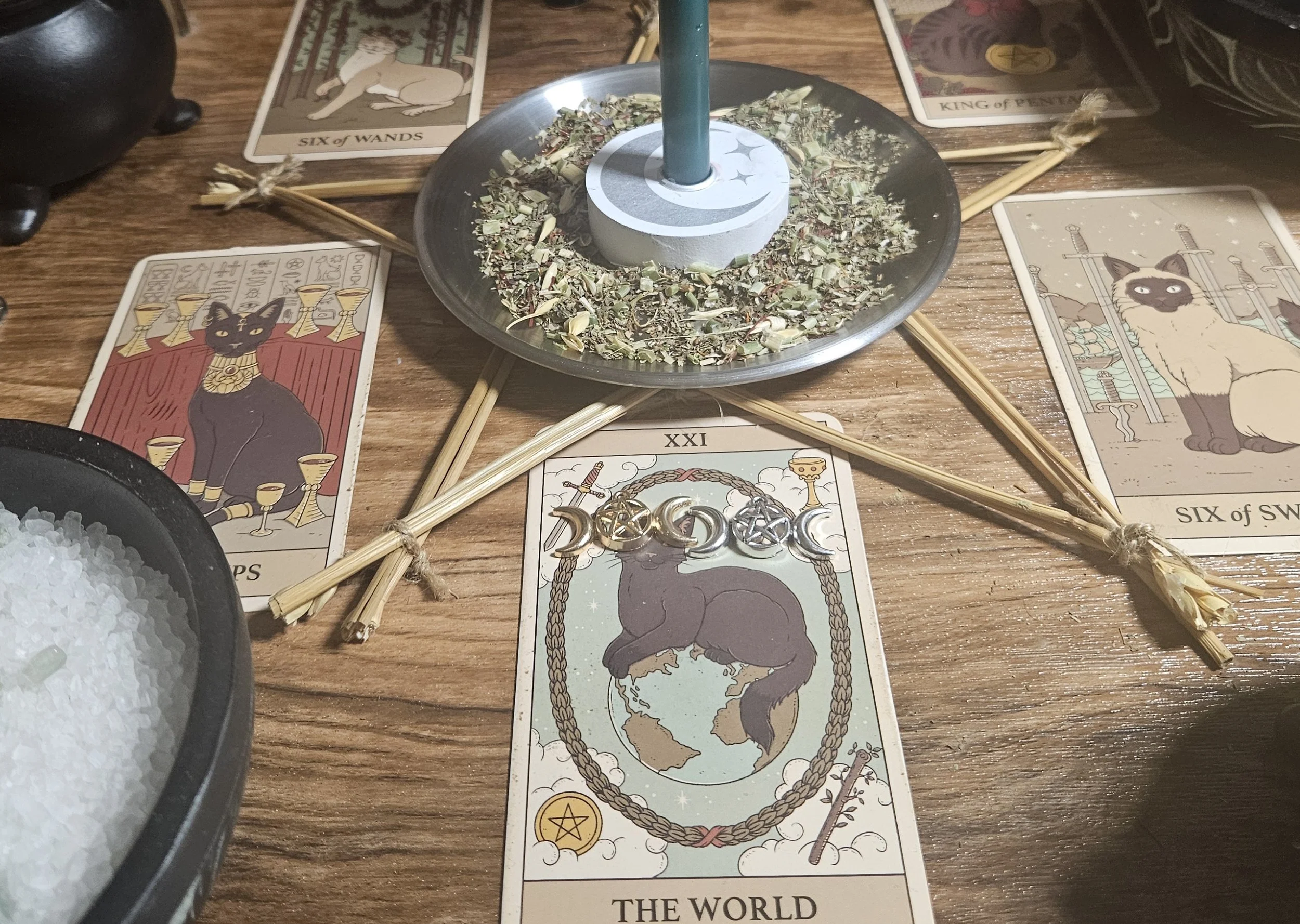 A world tarot deck featuring a cat resting on it, symbolizing a whimsical connection between tarot and companionship.