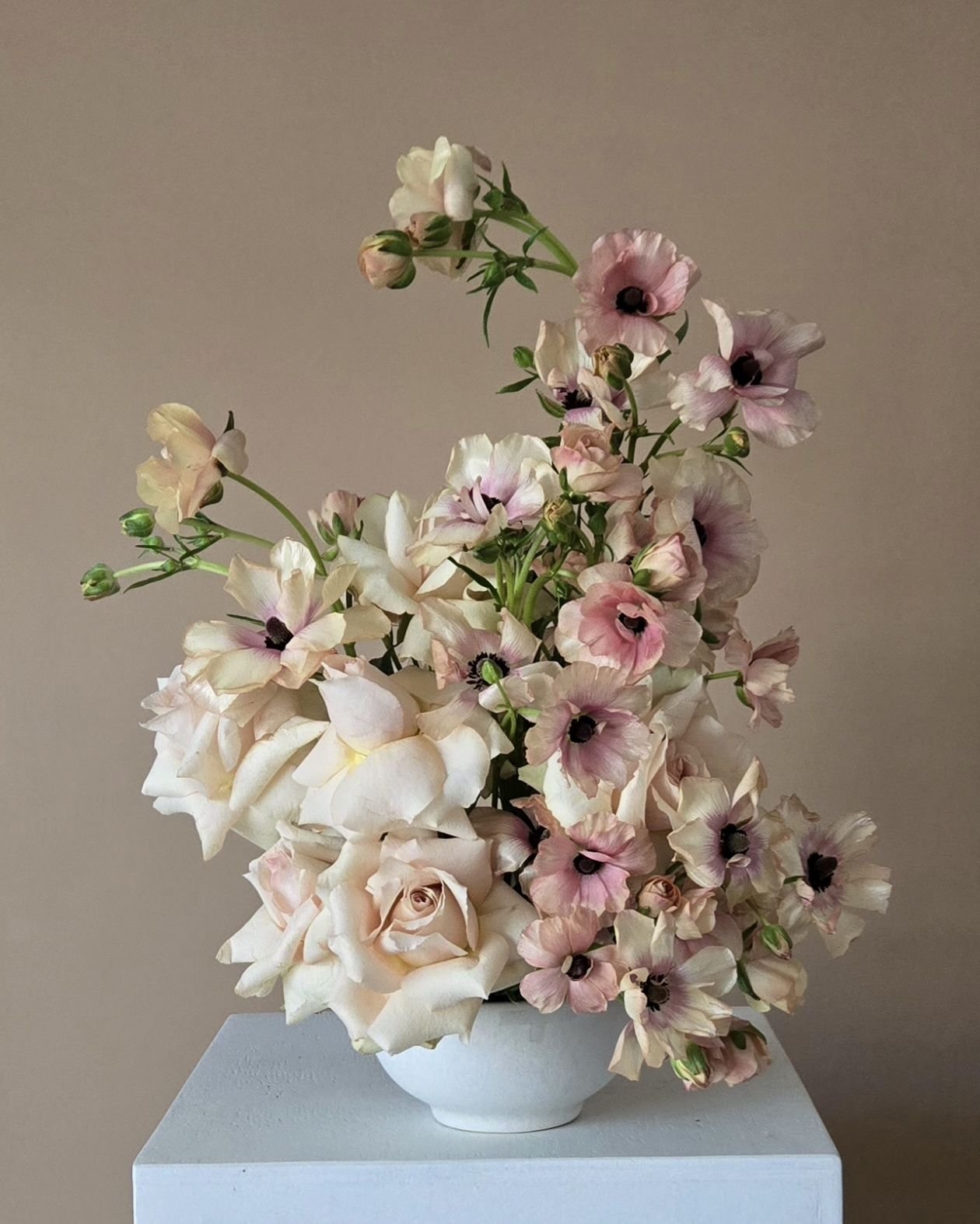 spring feminine soft pink arrangement in white bowl. Roses, butterfly ranunculus