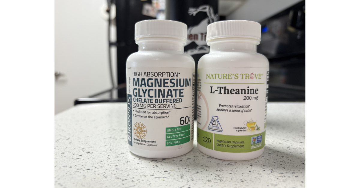 A bottle of Bronson Magnesium Glycinate and Nature’s Trove L-Theanine sitting on a white kitchen counter, representing a foundational nightly supplement stack for sleep and recovery.