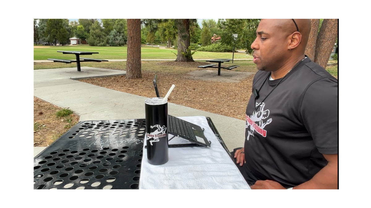 Eric Evans demonstrating a physiological sigh breathing exercise outdoors.