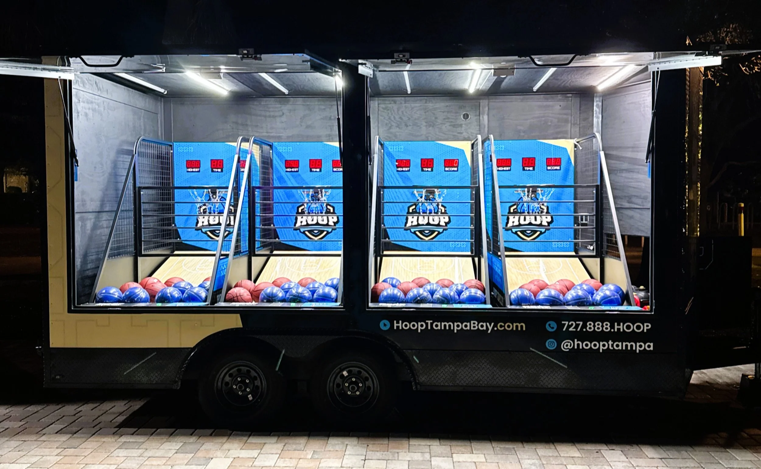 Hoop Tampa Bay mobile arcade basketball trailer featuring four illuminated, side-by-side basketball shooting lanes filled with blue balls, showcasing custom HOOP branding. Perfect for events, festivals, and corporate activations in the Tampa Bay area