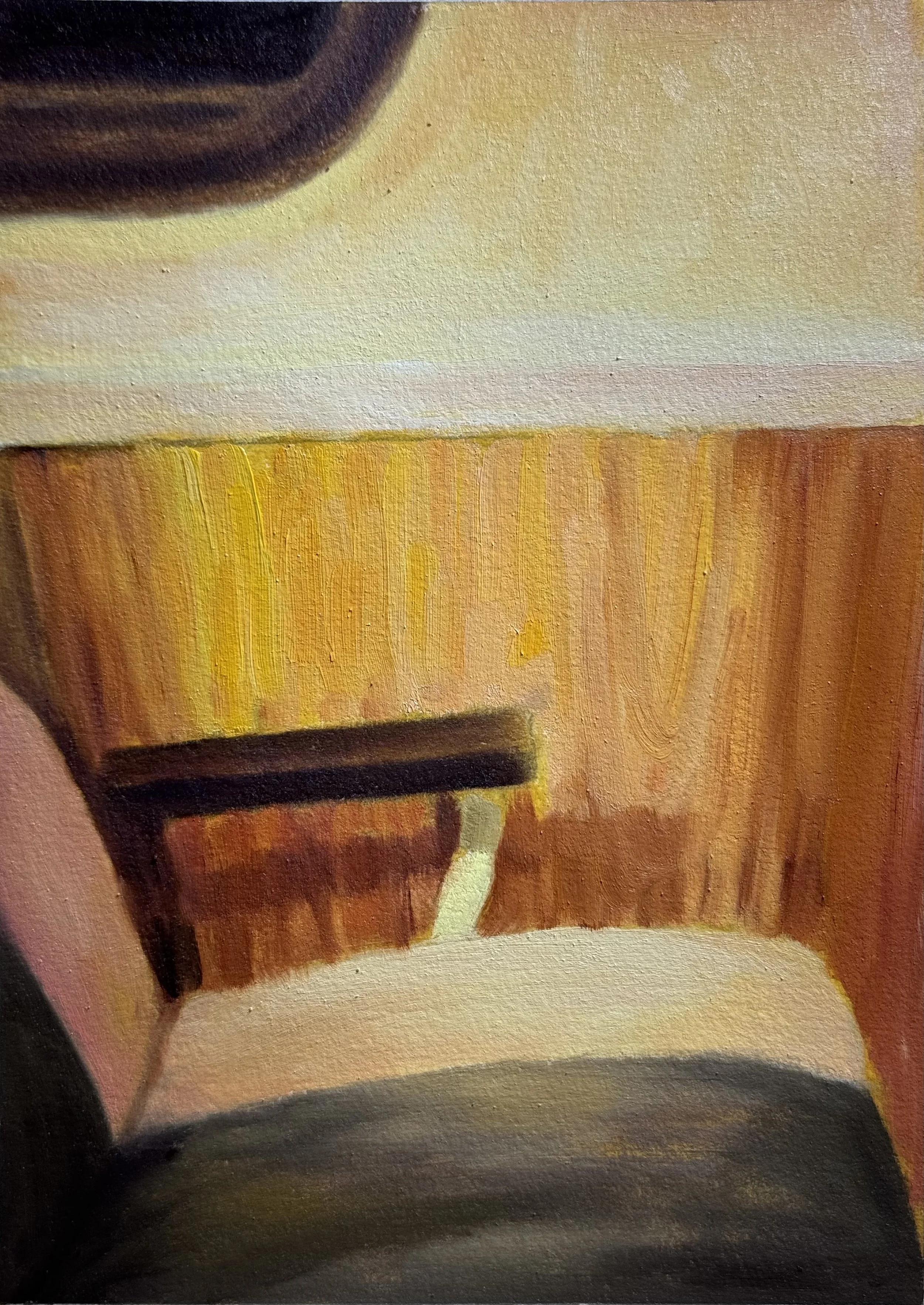 Close-up view of a wooden floor with a chair, part of a white table, and a person's foot in a shoe.