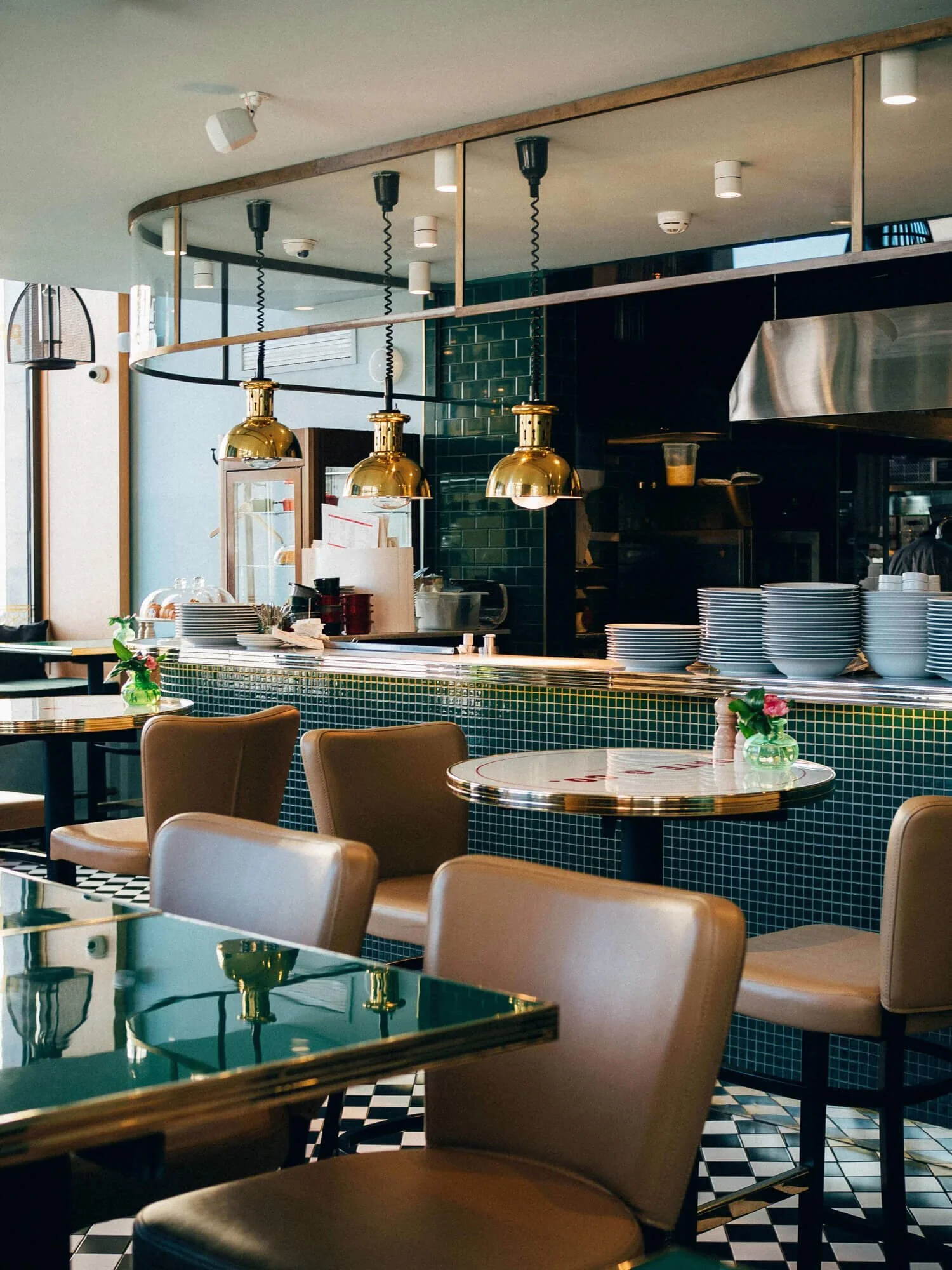Trendy restaurant interior with green glossy tile and beige seats in Soho, New York