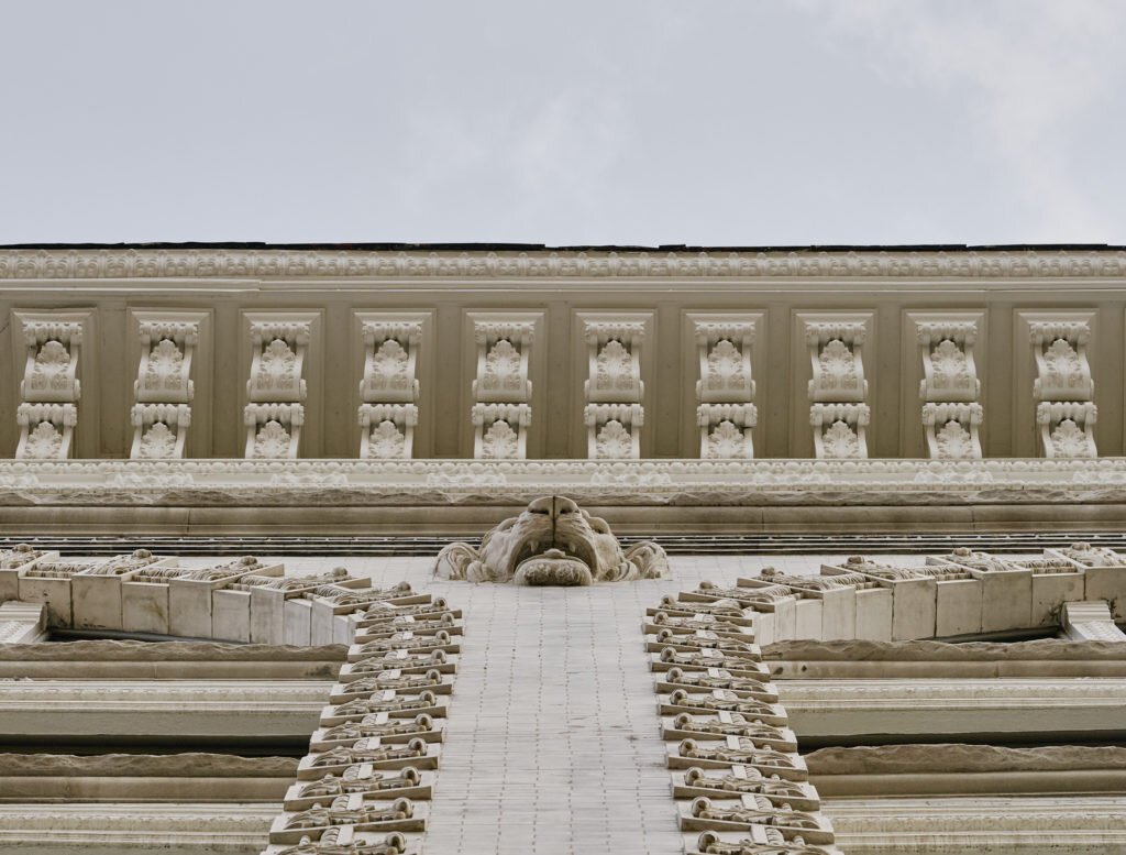 Cast iron building detail of intricate cornice with a stone lion head