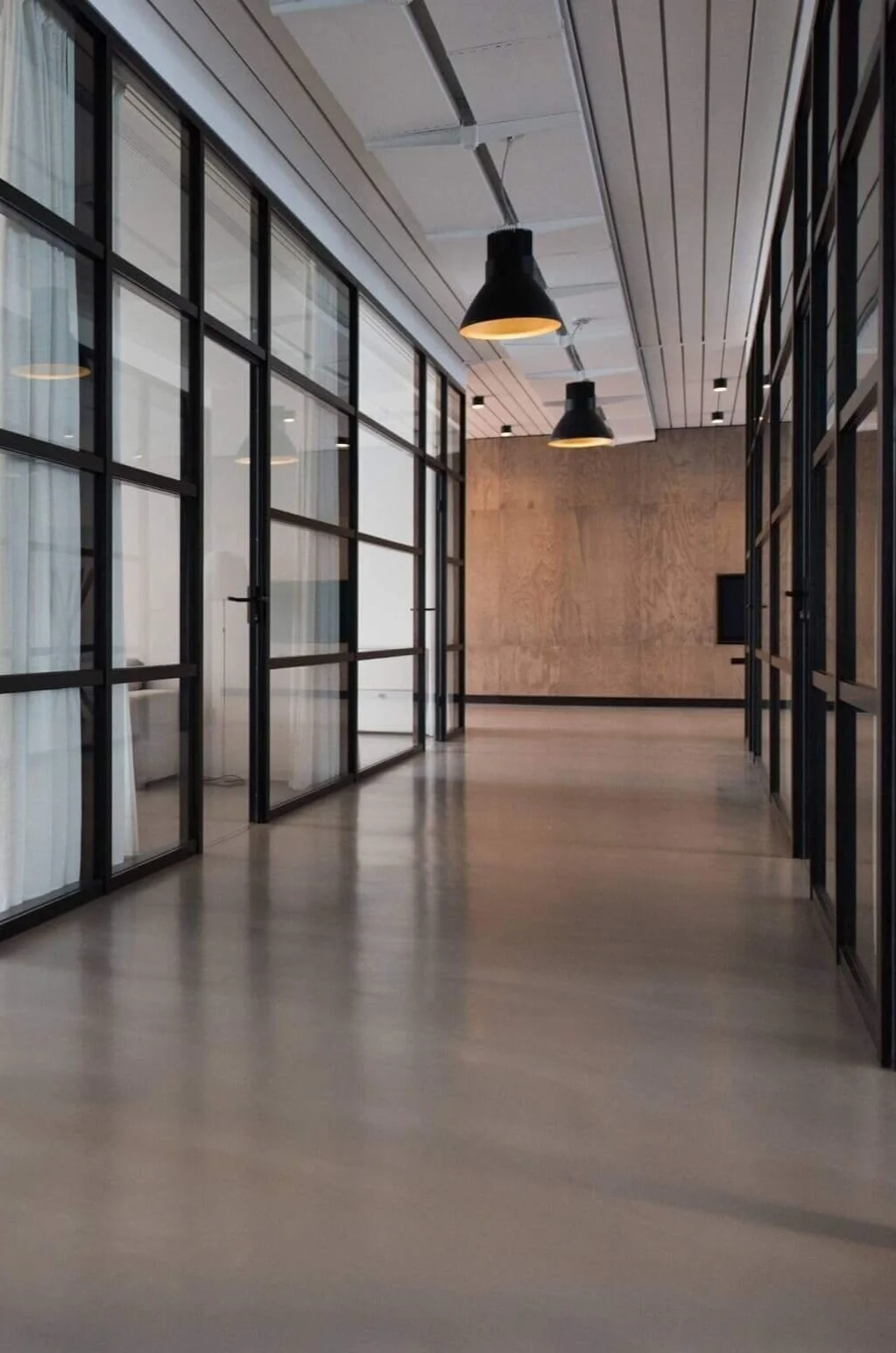 Hallway of an office with glass partitions for private offices on either side