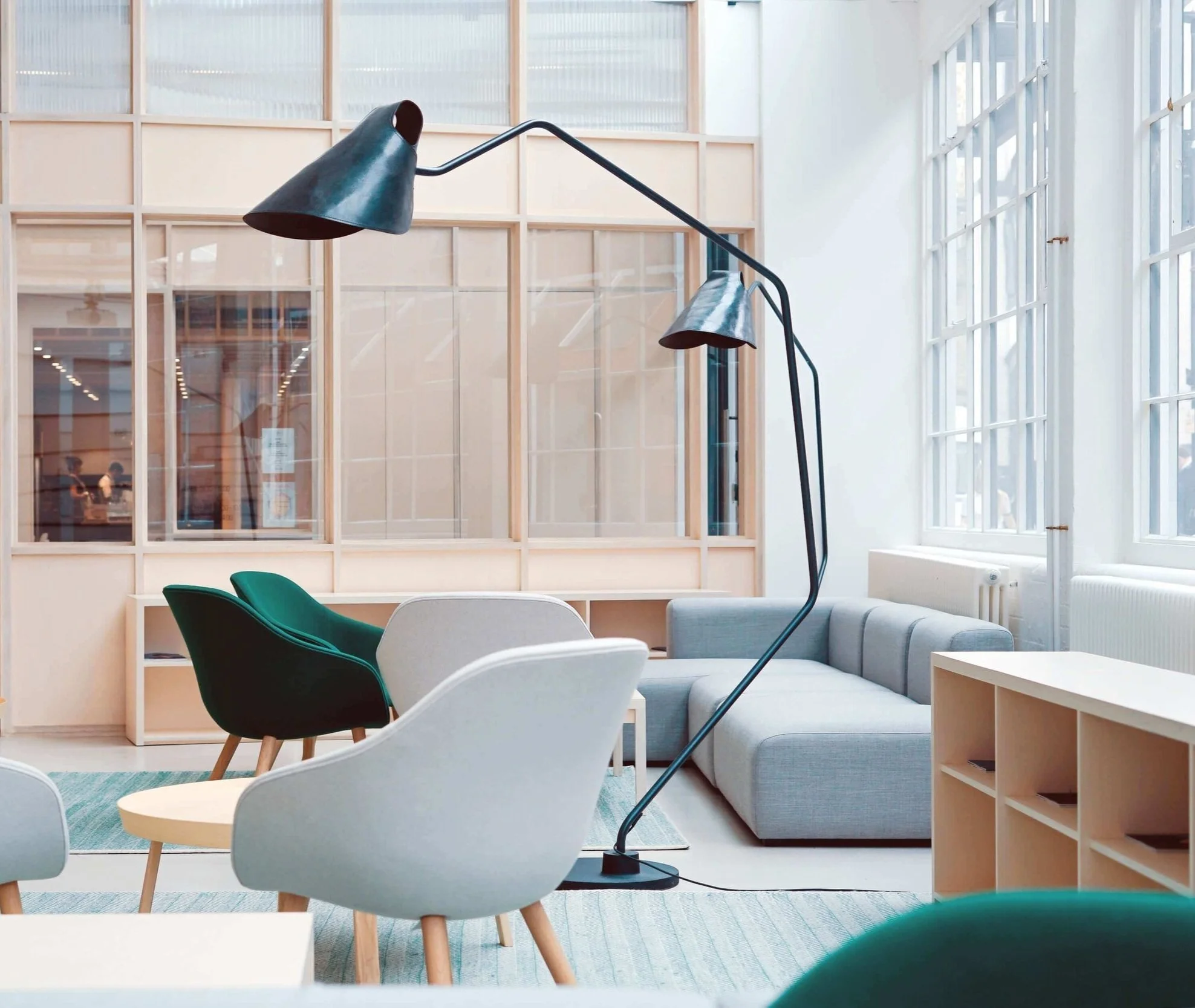 Office lobby with several grey and green chairs and a tall black lamp
