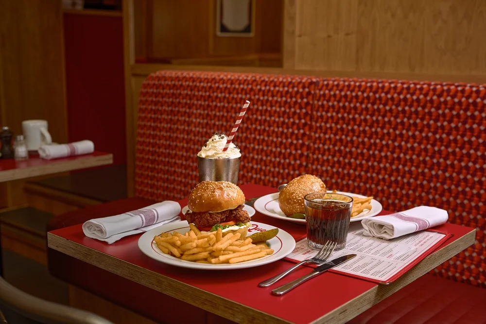 Places to Eat Near Glasgow's Big Venues: Scotstoun, Hampden, the Hydro and More 9 A fried chicken burger with fries and a milkshake on a red table in a diner booth