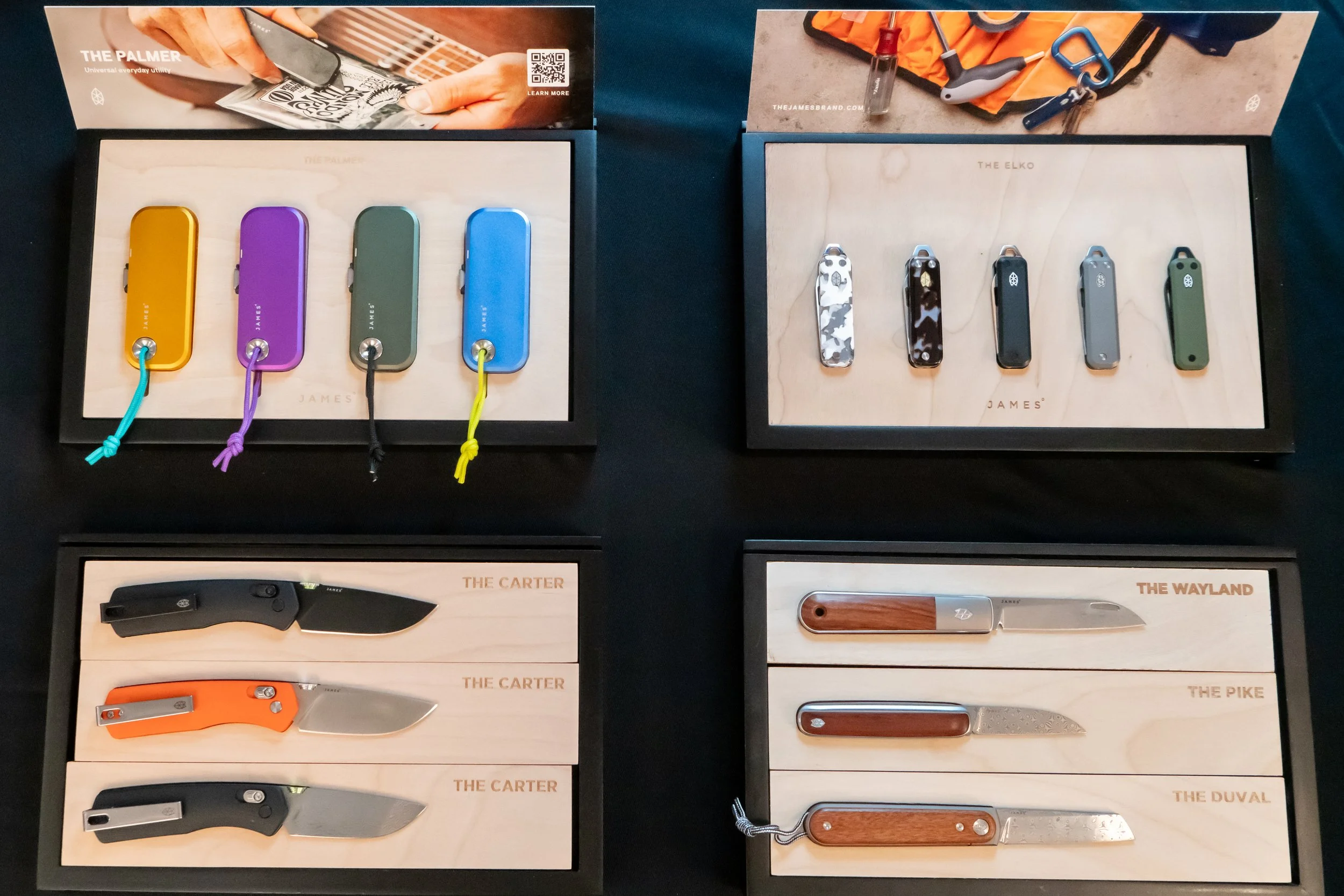Display of colorful compact flashlights, patterned pocket knives, and wooden-handled knives at a retail store.