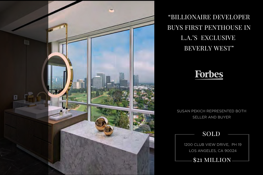 Interior view of a luxurious bathroom with double sinks, gold fixtures, a large mirror, and a marble countertop, overlooking a city skyline through large windows.