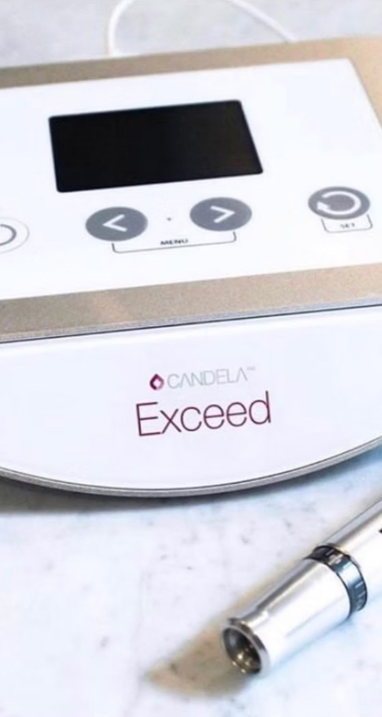 A medical device with a black digital screen and control buttons, with the brand name 'CANDela' and 'Exceed'.