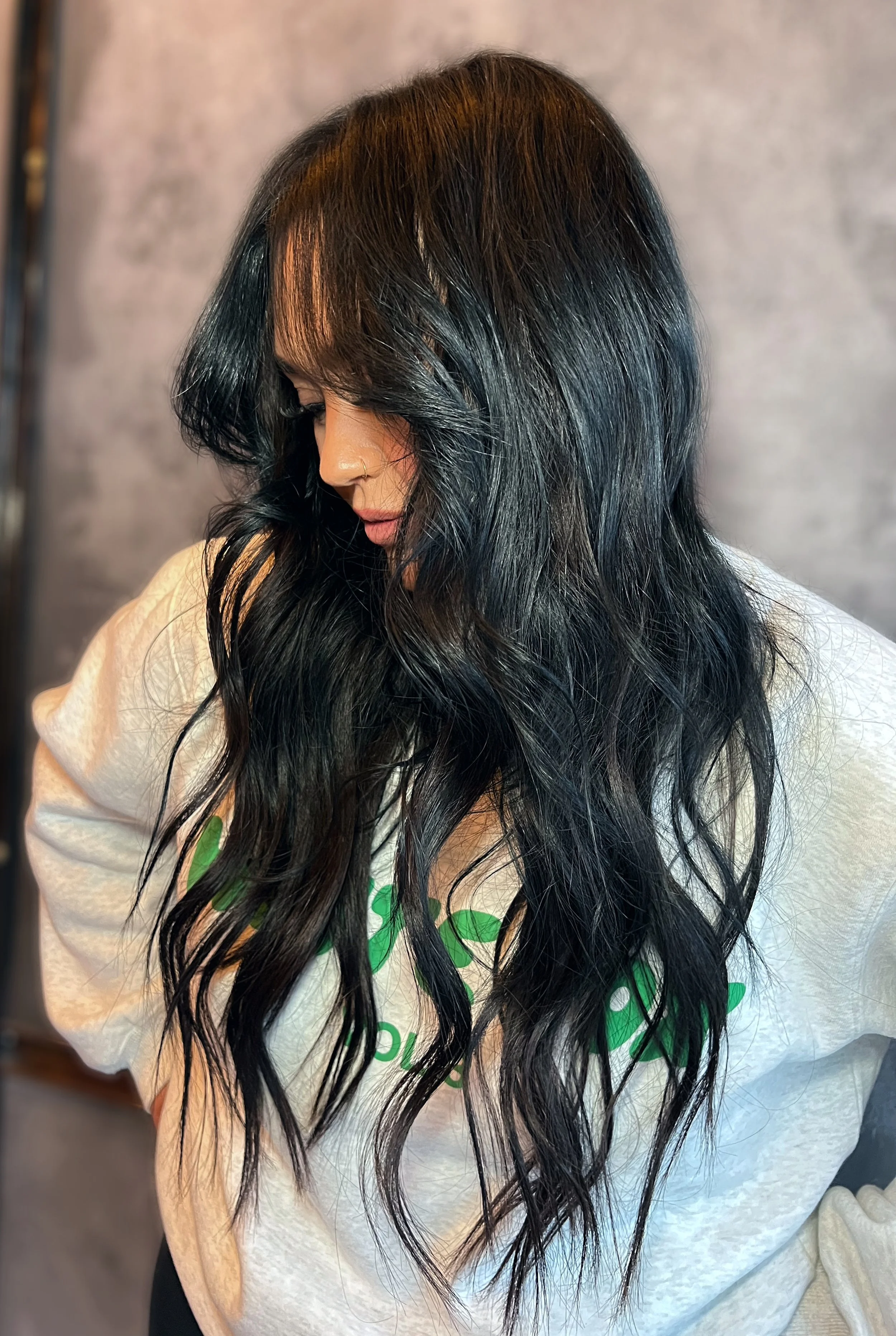 Wearing 22-inch hand-tied premium hair extensions. Long, wavy black hair blends naturally for a scalp-healthy, luxurious style using The Luna Method in Westchester, NY. installed by certified luna method trainer Stefanie maccabee in white plains ny