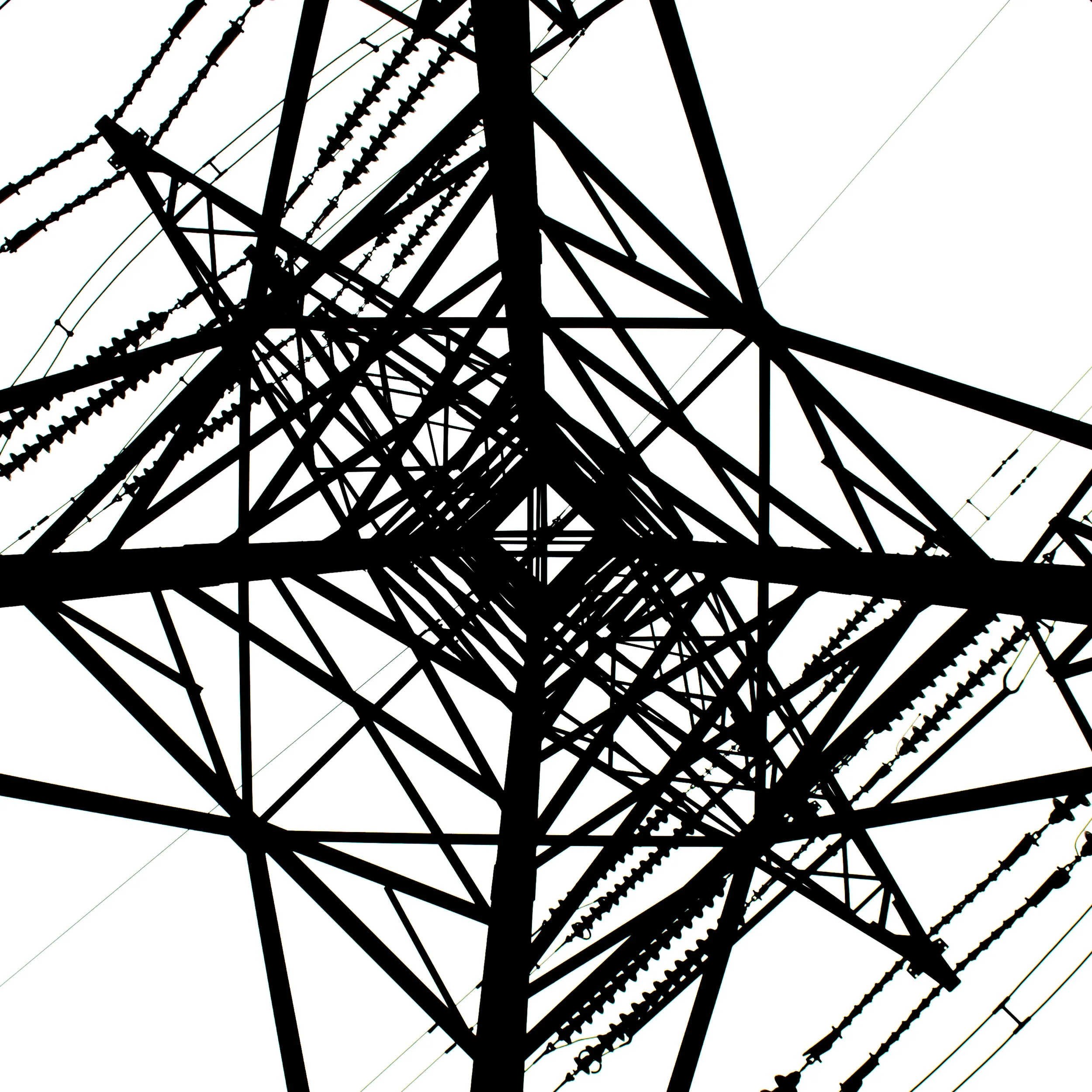 Silhouette of a high-voltage transmission tower viewed from below against a white sky.