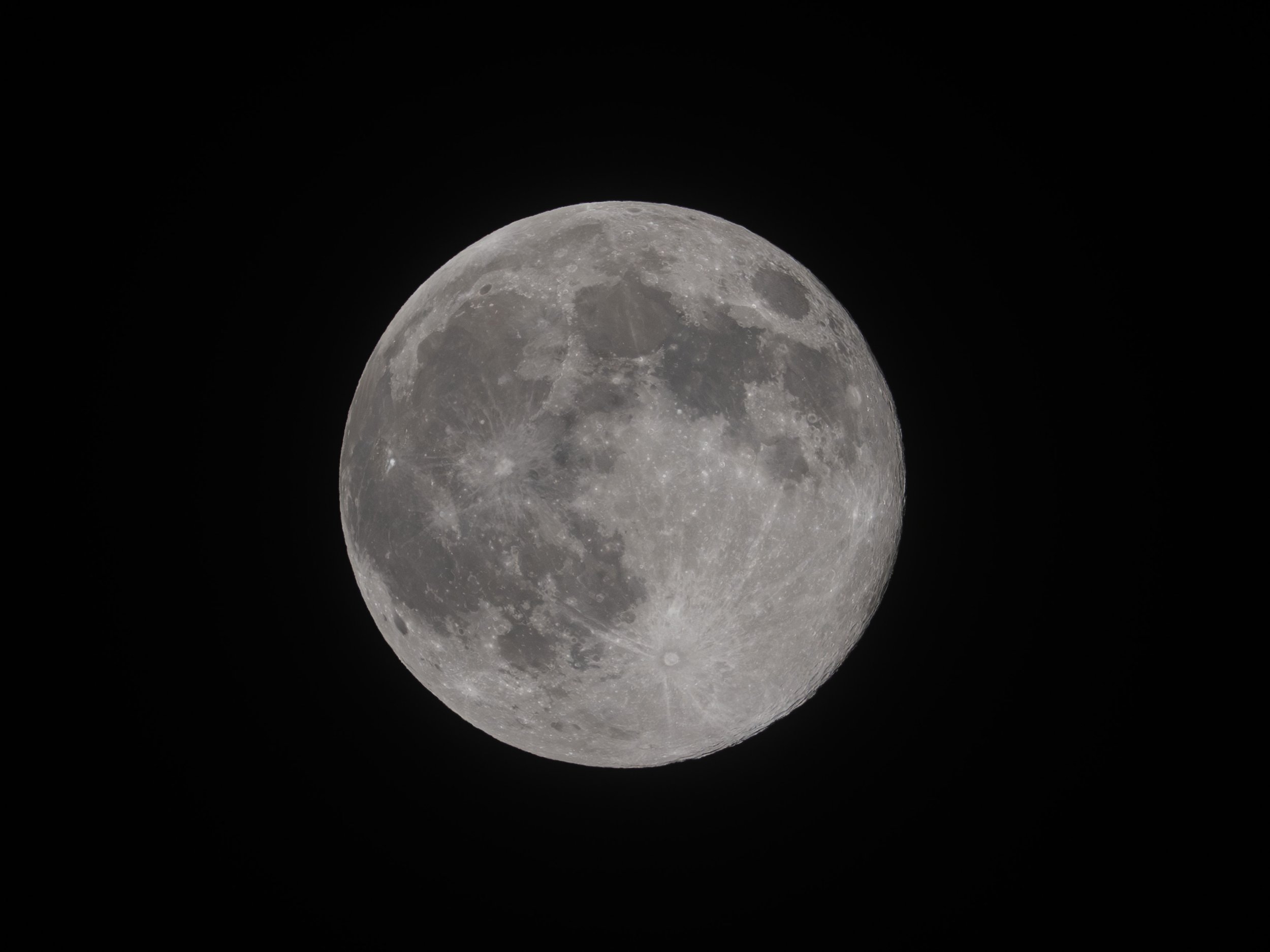 Photograph of the full moon against a black night sky.