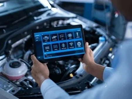 Technician analyzing vehicle diagnostics and performance data on a digital tablet to monitor efficiency and key performance indicators