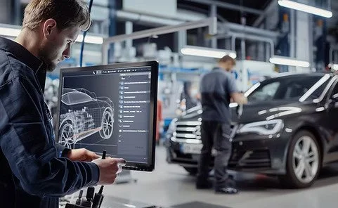 Technician analyzing vehicle schematics on a digital screen using AI to detect ADAS systems and ensure compliance