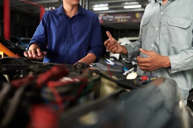 Consultant and technician discussing repair processes in an auto shop, symbolizing leadership and collaboration in collision consulting