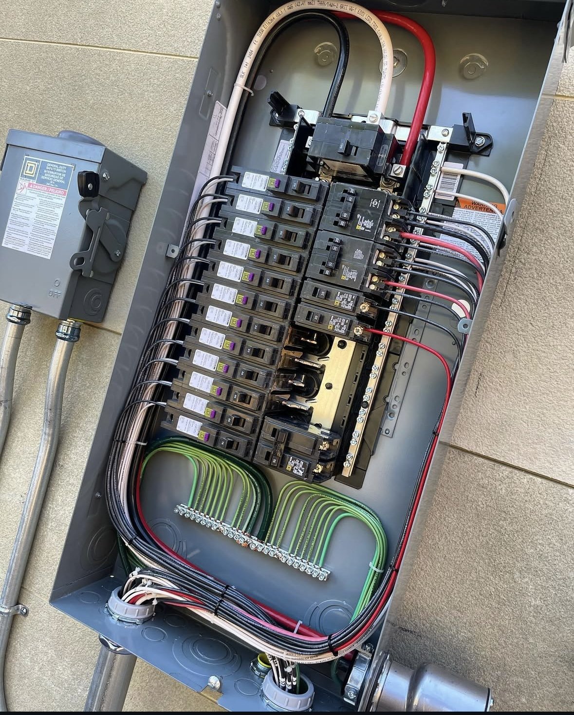 Person wearing brown gloves testing electrical circuit breaker box with a digital multimeter.
